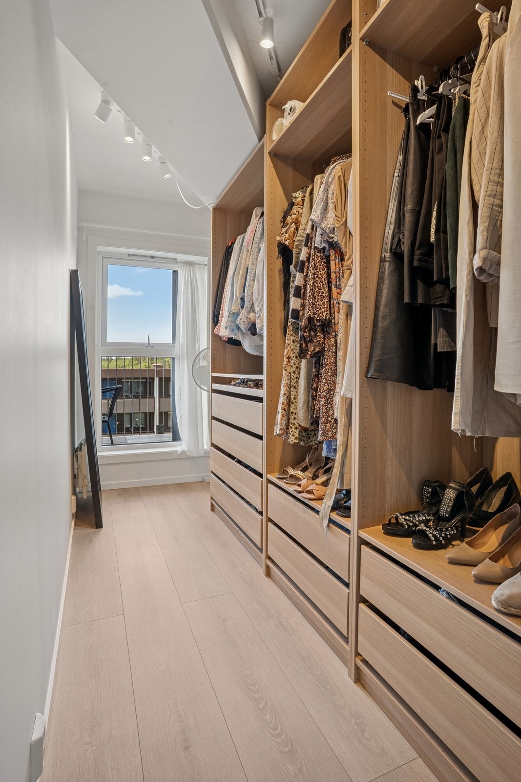 Walk-in-garderobe med god innredning og plass til sminkepult ved vinduet. Galleribilde