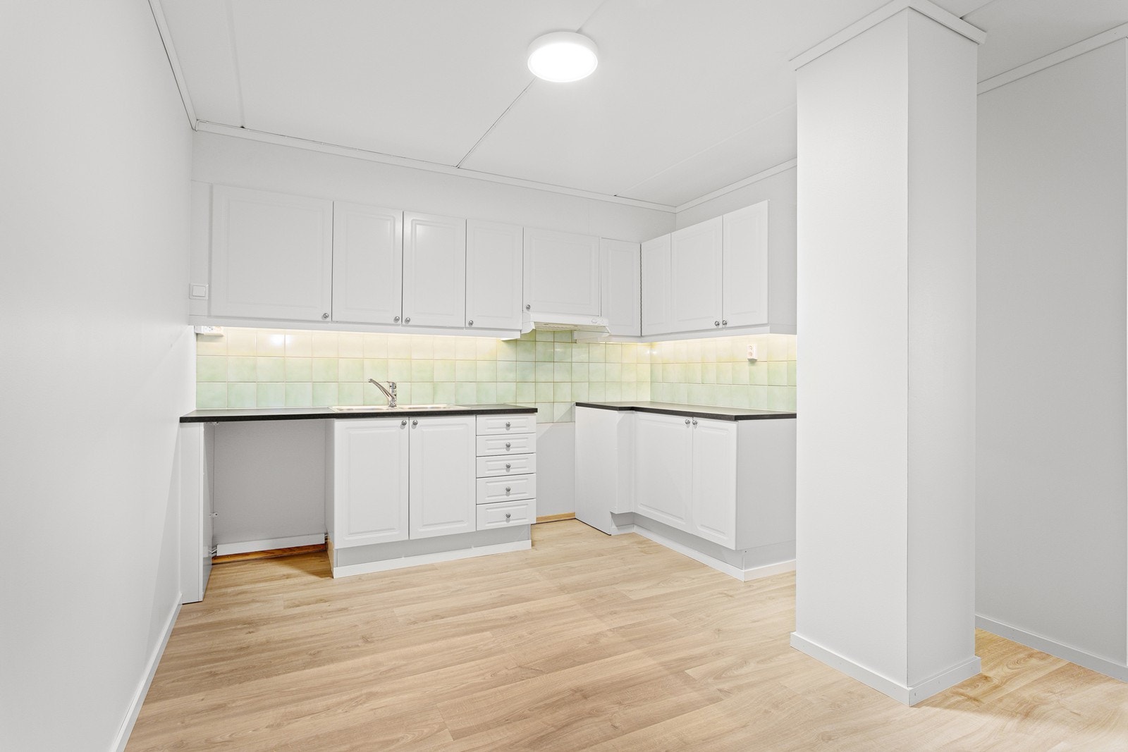 Praktisk kjøkkeninnredning med plass til komfyr, oppvaskmaskin og kjøleskap. Godt med skap- og benkeplass. Galleribilde