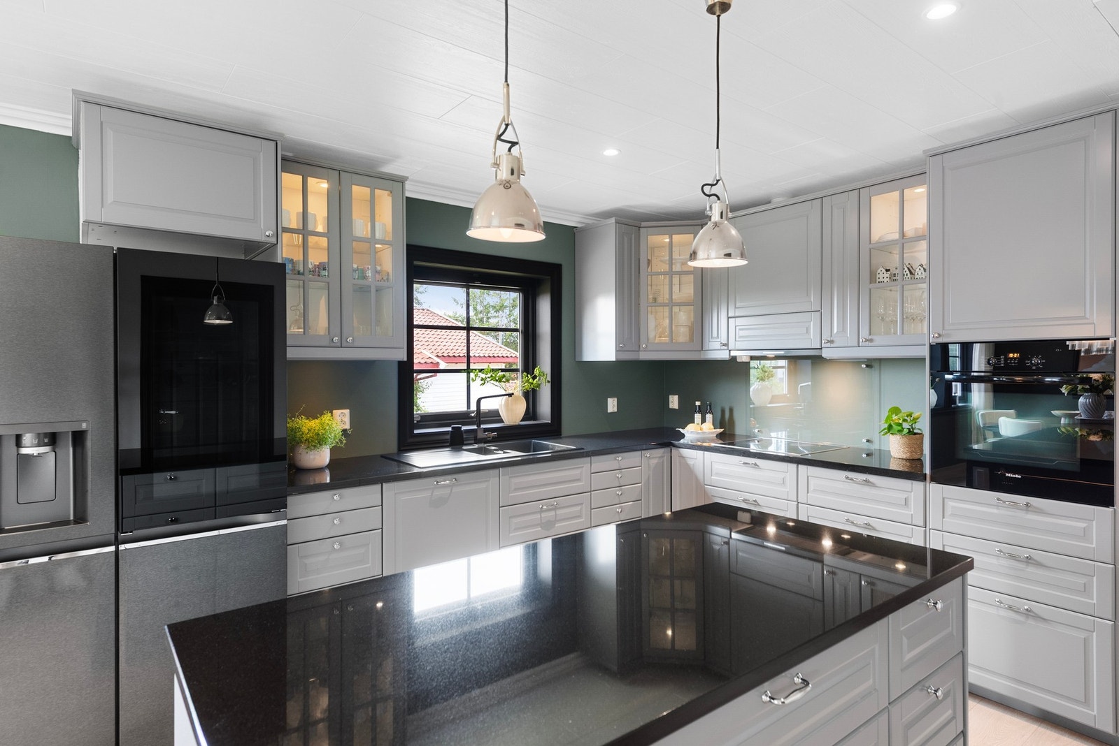 Kjøkken med profilerte fronter og benkeplate i stein - kjøkkenøyen tilfører både oppbevaring og arbeidsflate Galleribilde