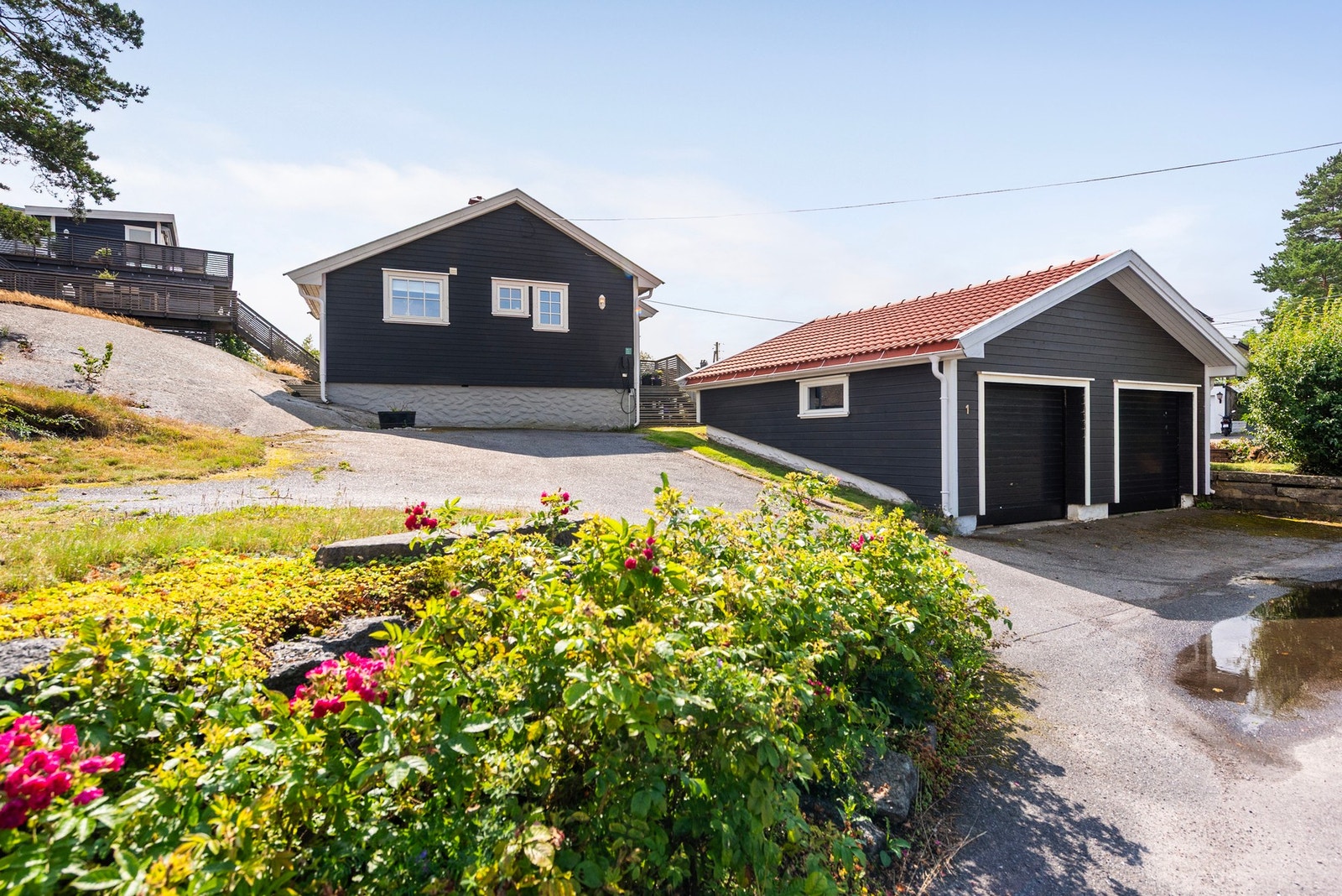 Asfaltert innkjørsel og dobbel garasje gir rikelig med plass til parkering for både deg og gjestene Galleribilde