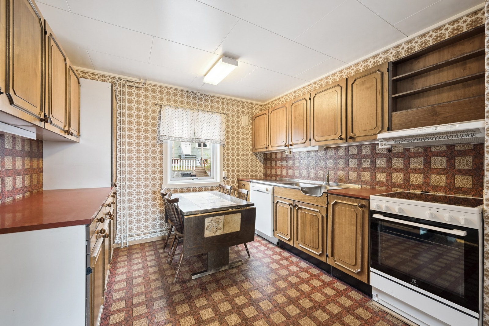 Kjøkkenet har brune, profilerte dører og rikelig med skap- og benkeplass - perfekt for deg som ønsker både karakter og funksjon. Galleribilde