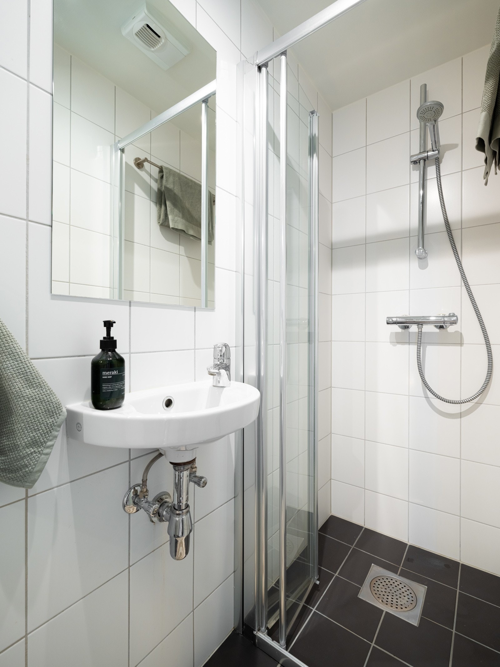 Lyst og flislagt baderom med gulvvarme. Baderommet har vegghengt servant, speil, speilskap, dusjnisje med skyvedør av glass og gulvstående toalett. Galleribilde