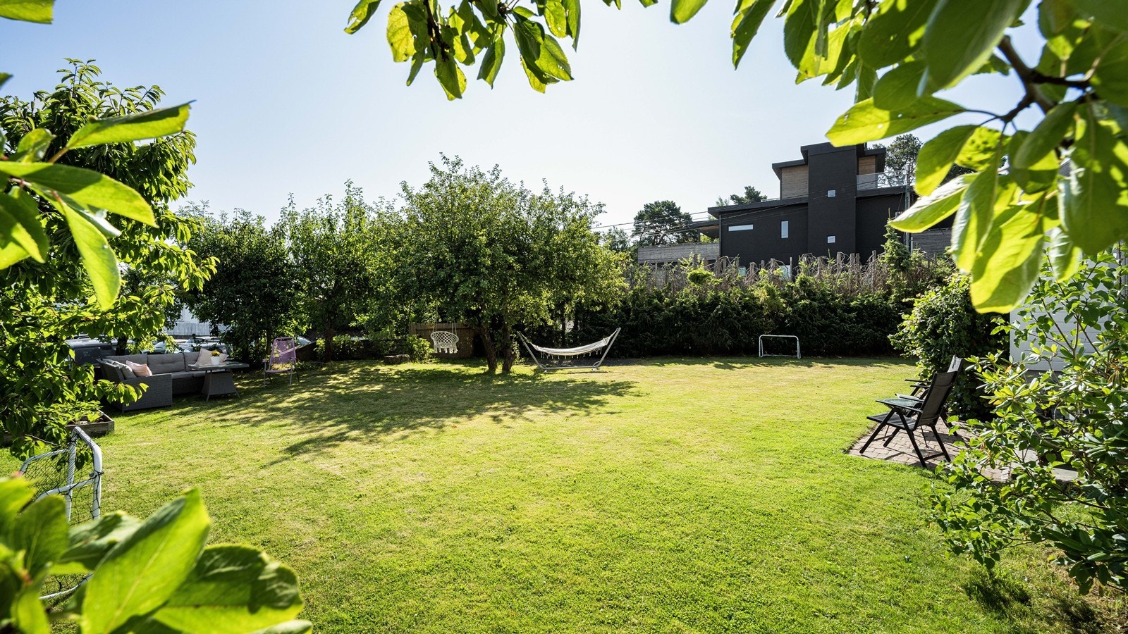 Fantastisk hage med plen, bed og diverse frukttrær Galleribilde