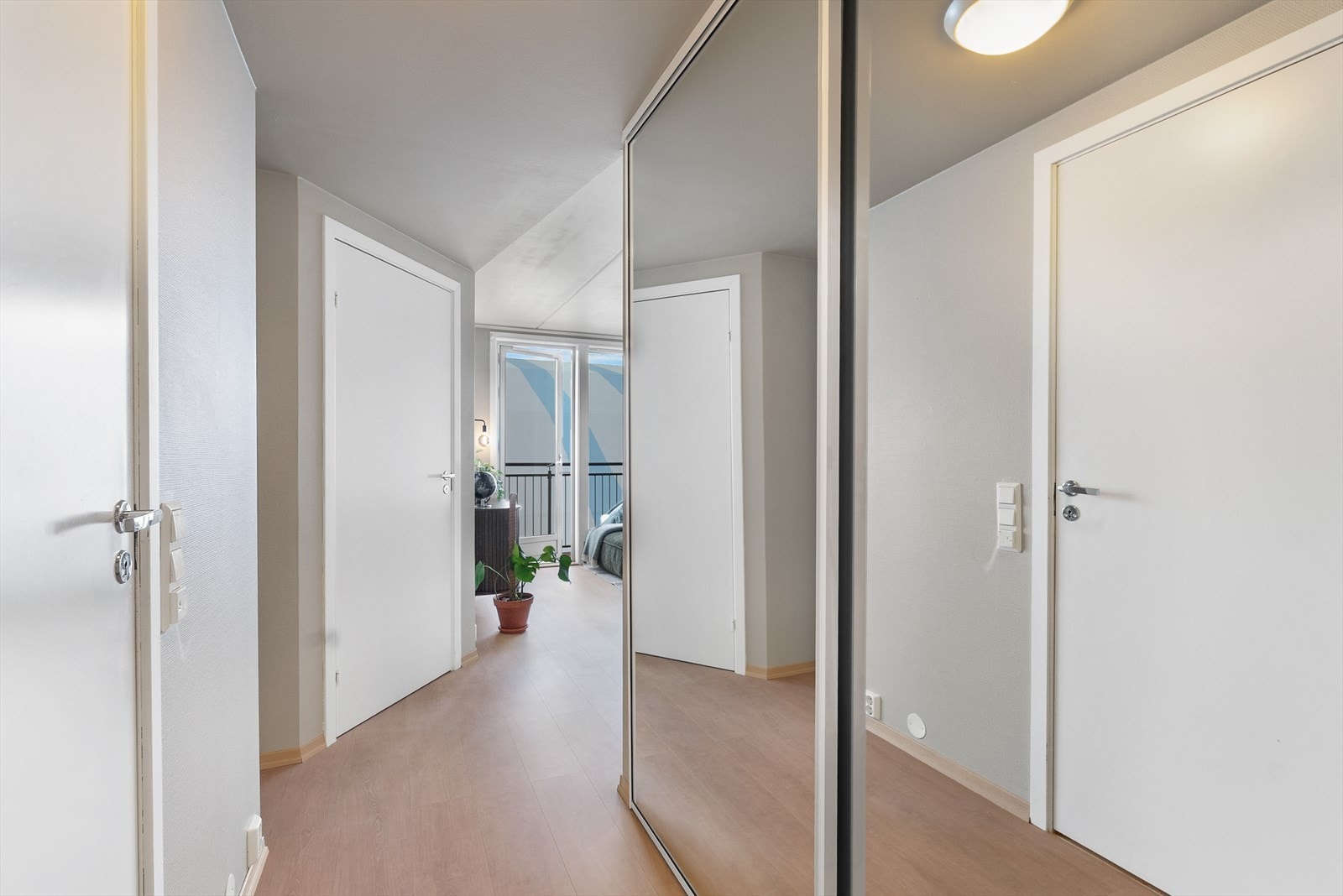 Vi blir ønsket velkommen inn i en lys entré med romslig skyvedørsgarderobe. Galleribilde