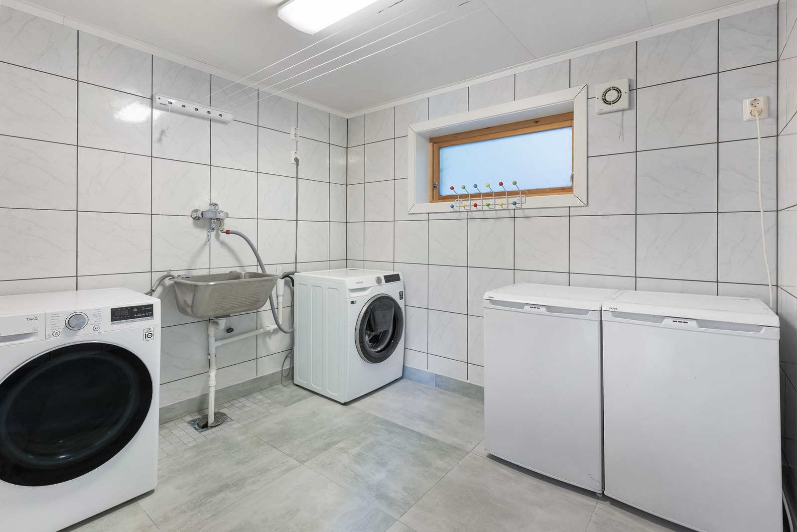 Innenfor kjøkkenet ligger vaskerommet, med opplegg for oppvaskmaskin og tørketrommel. Galleribilde