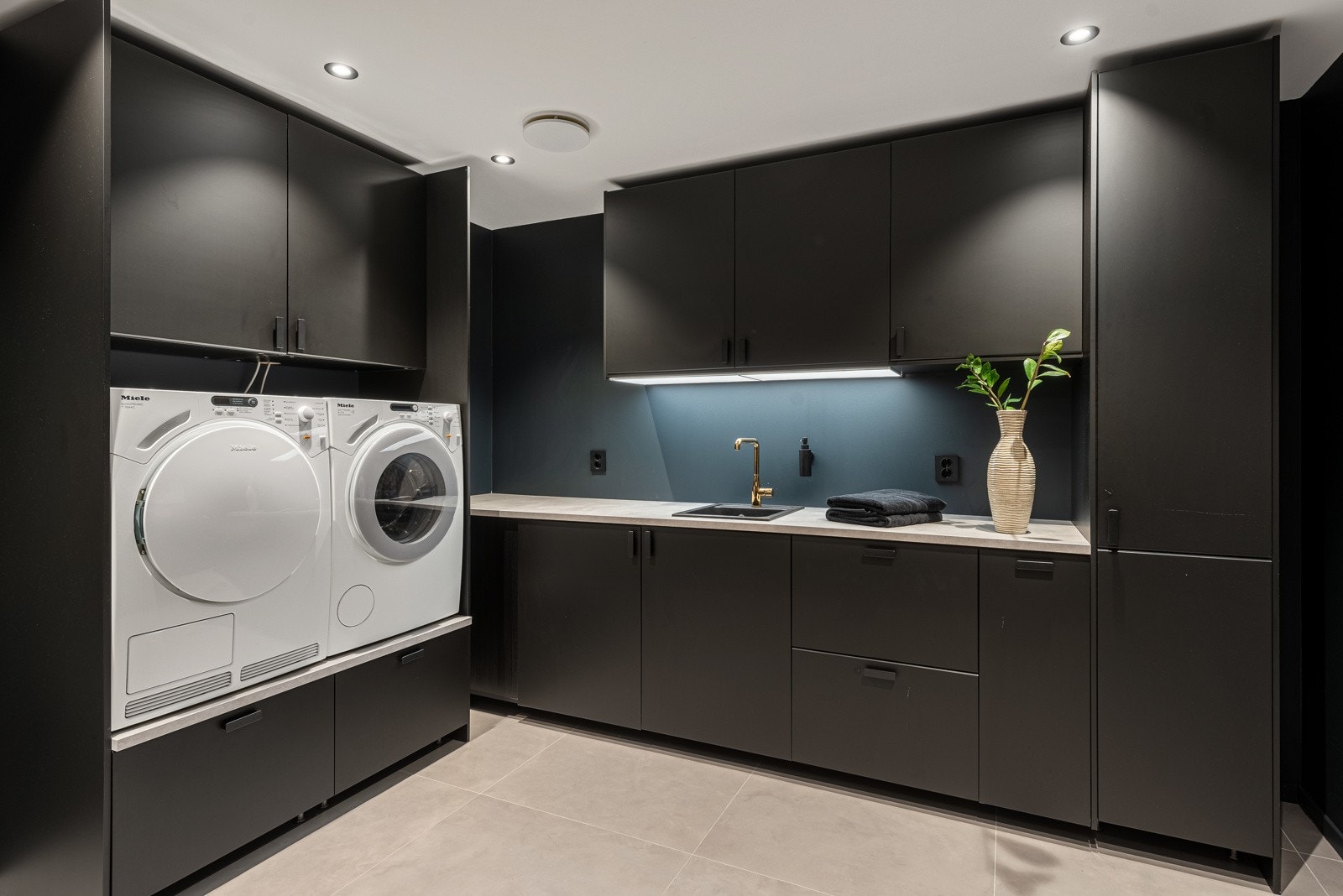 I kjelleren er det et stort vaskerom med opplegg for vaskemaskin og tørketrommel. Det er godt med oppbevaringsplass i skap og på benken Galleribilde