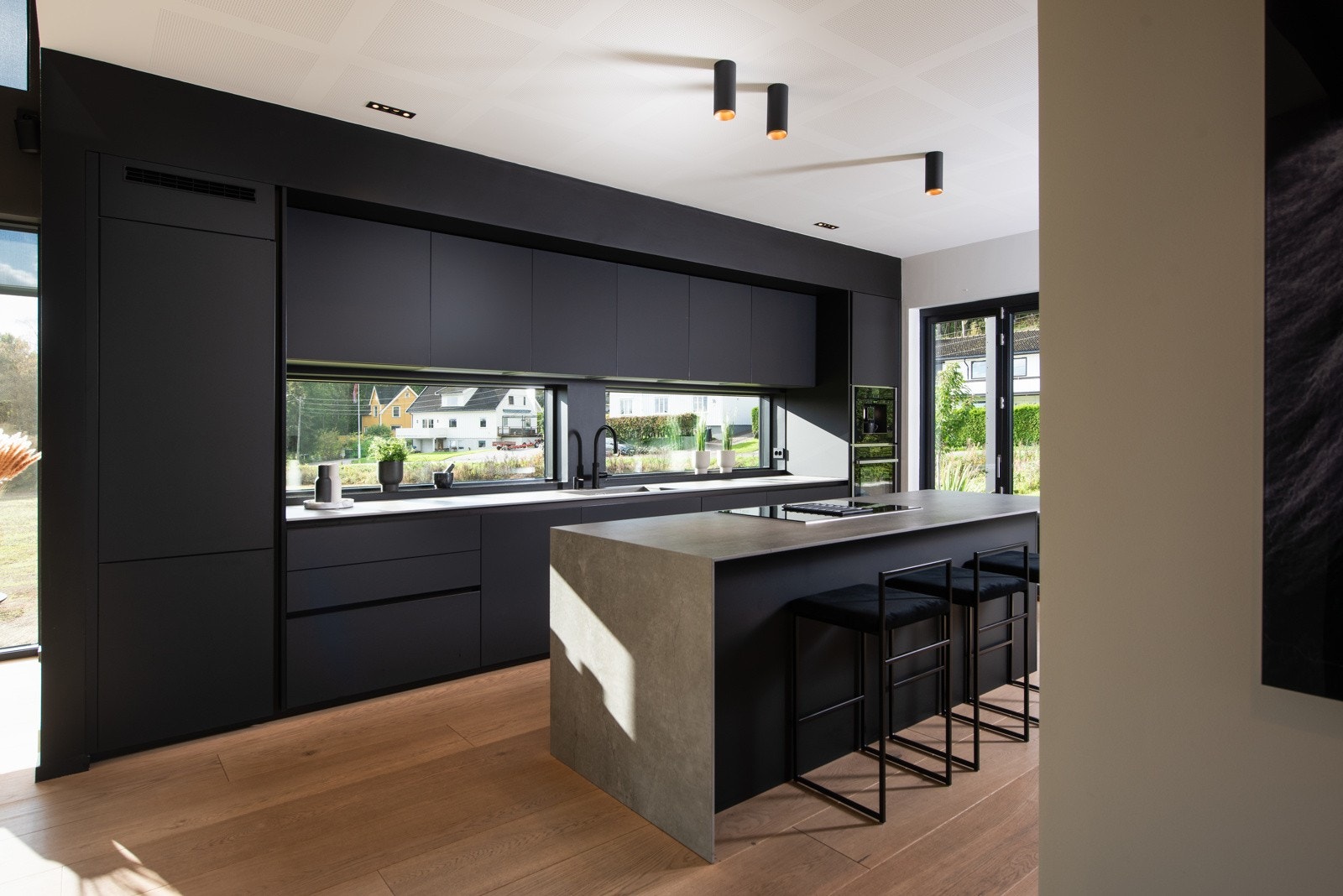 Med barstoler rundt kjøkkenøyen kan man holde kokken med selskap, bidra med leksehjelp under matlaging eller bare ta en rask matbit i farta Galleribilde