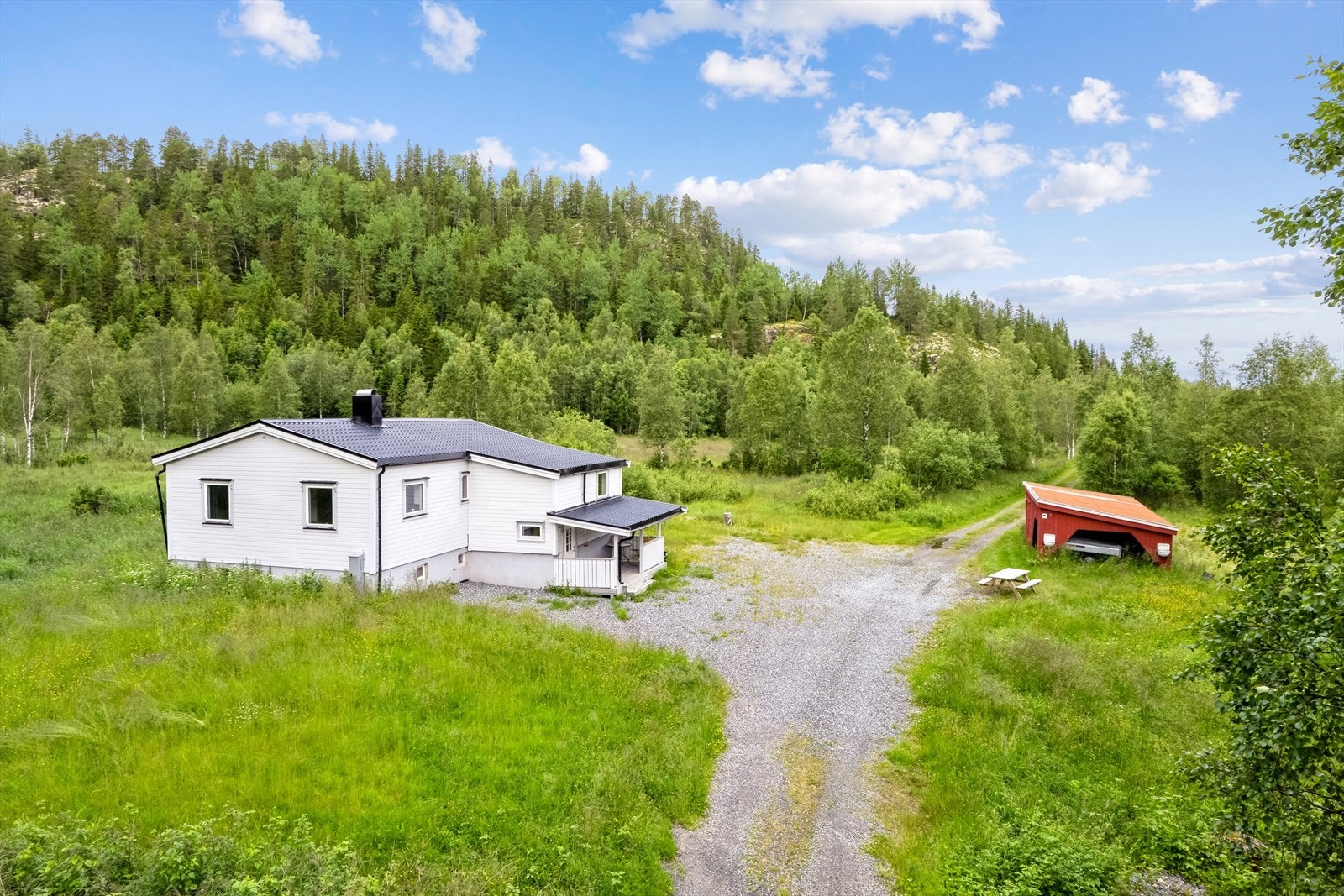 Området rundt boligen er flatt med gruslagt gårdsplass. Videre ut er det en landevei som fører til to hytter og ett naust. Galleribilde