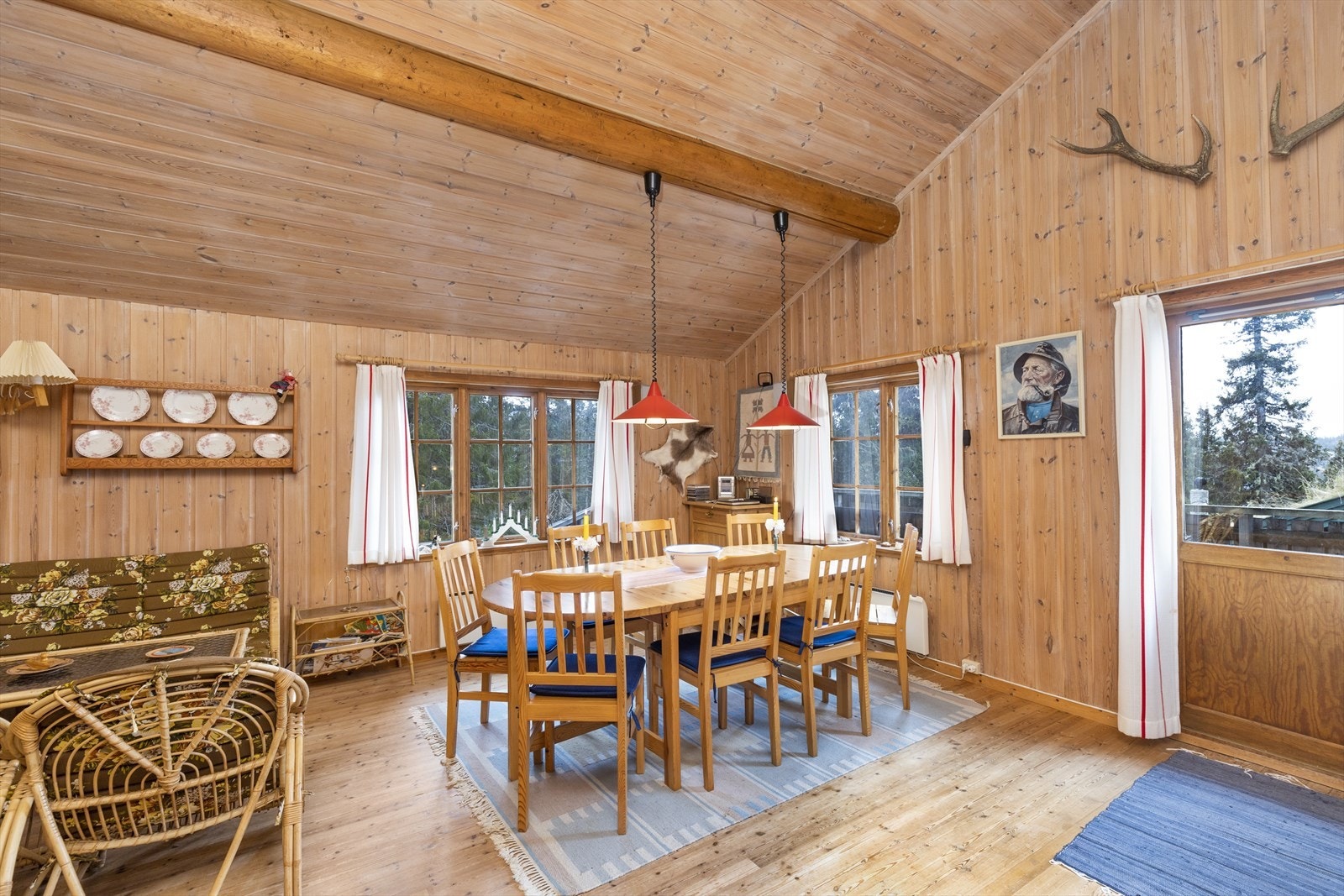 Fra stuen er det utgang til terrasse. Hytta har god takhøyde med bjelker i taket i stuen. Galleribilde