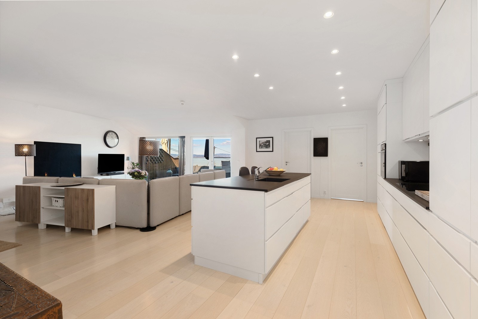 Stor åpen kjøkken løsning med utsikt til Oslo. Mye skap og benkeplass Galleribilde