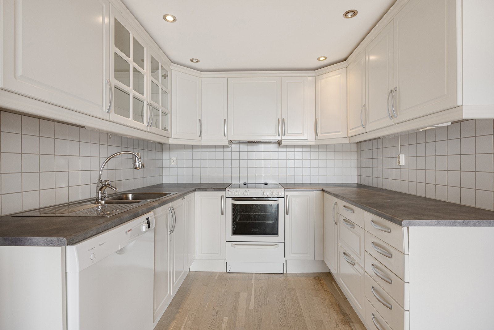 Vinkelformet kjøkken med god skap- og benkeplass. Galleribilde