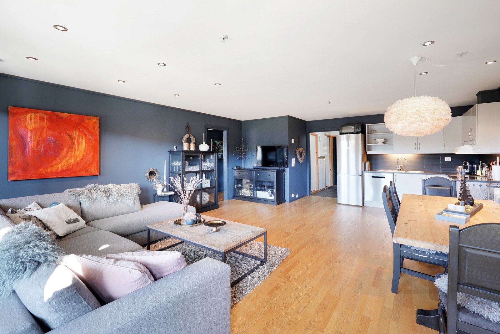 I stuen er det parkett på gulvet, mørk blåfarge på veggene og downlights i tak Galleribilde