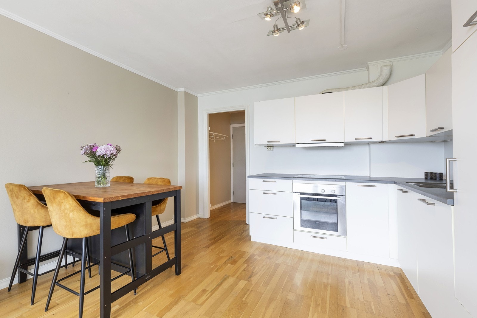 Kjøkkenet har integrerte hvitevarer som kjøleskap, oppvaskmaskin, ovn og platetopp Galleribilde