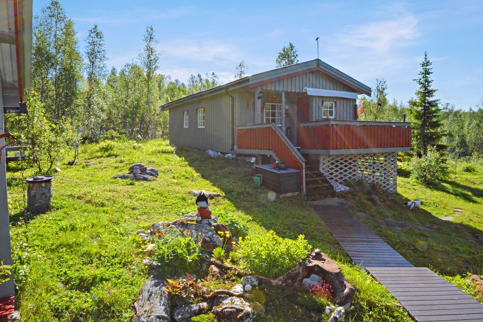 Hytten har en pent opparbeidet uteområde samt gangbaner av tre mellom hytten og uthuset Galleribilde