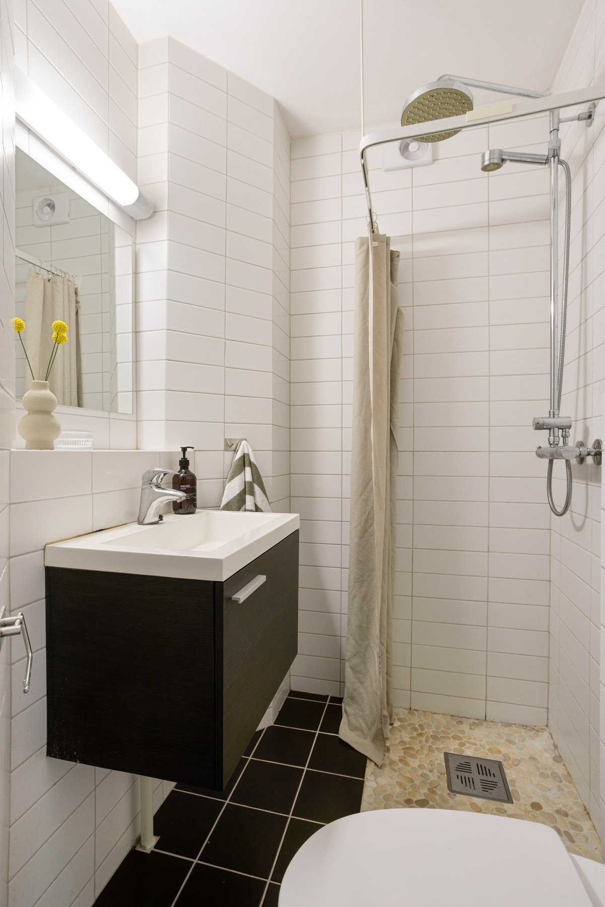 Innredningen består av vegghengt toalett og dusjhjørne med forheng, to-greps armatur og regnfallsdusj. Galleribilde