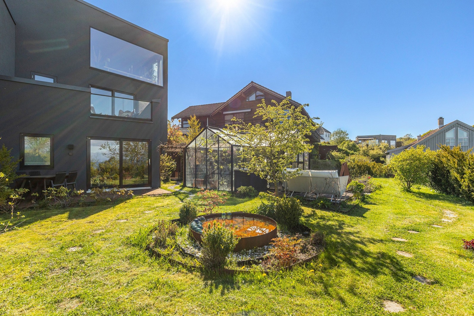 Pent opparbeidet hage med plen og prydbusker Galleribilde