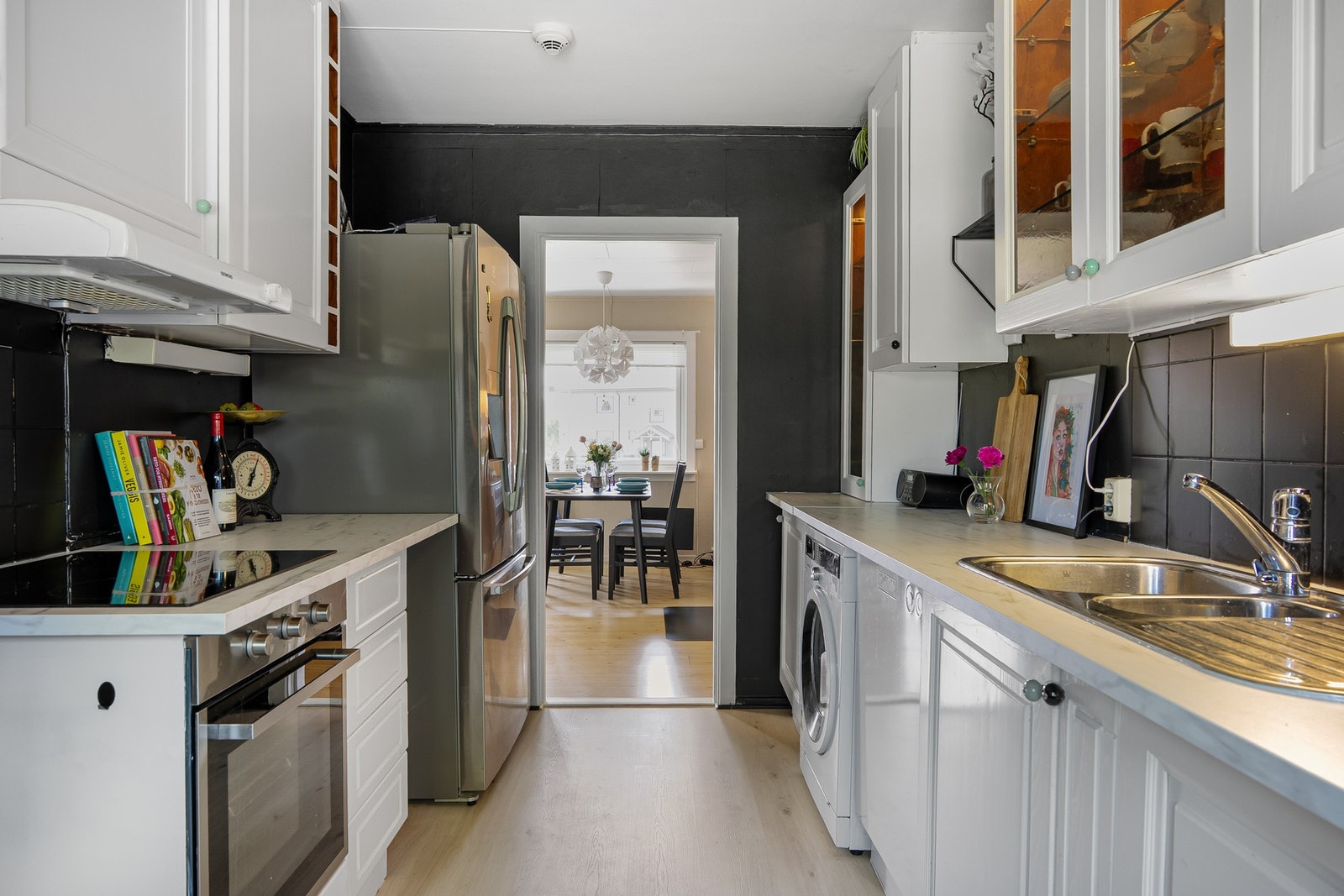 Kjøkkenet er utstyrt med integrerte hvitevarer som keramisk steketopp, stekeovn og oppvaskmaskin. Et frittstående kombiskap med frysedel og vann-/isdispenser følger også med. Galleribilde