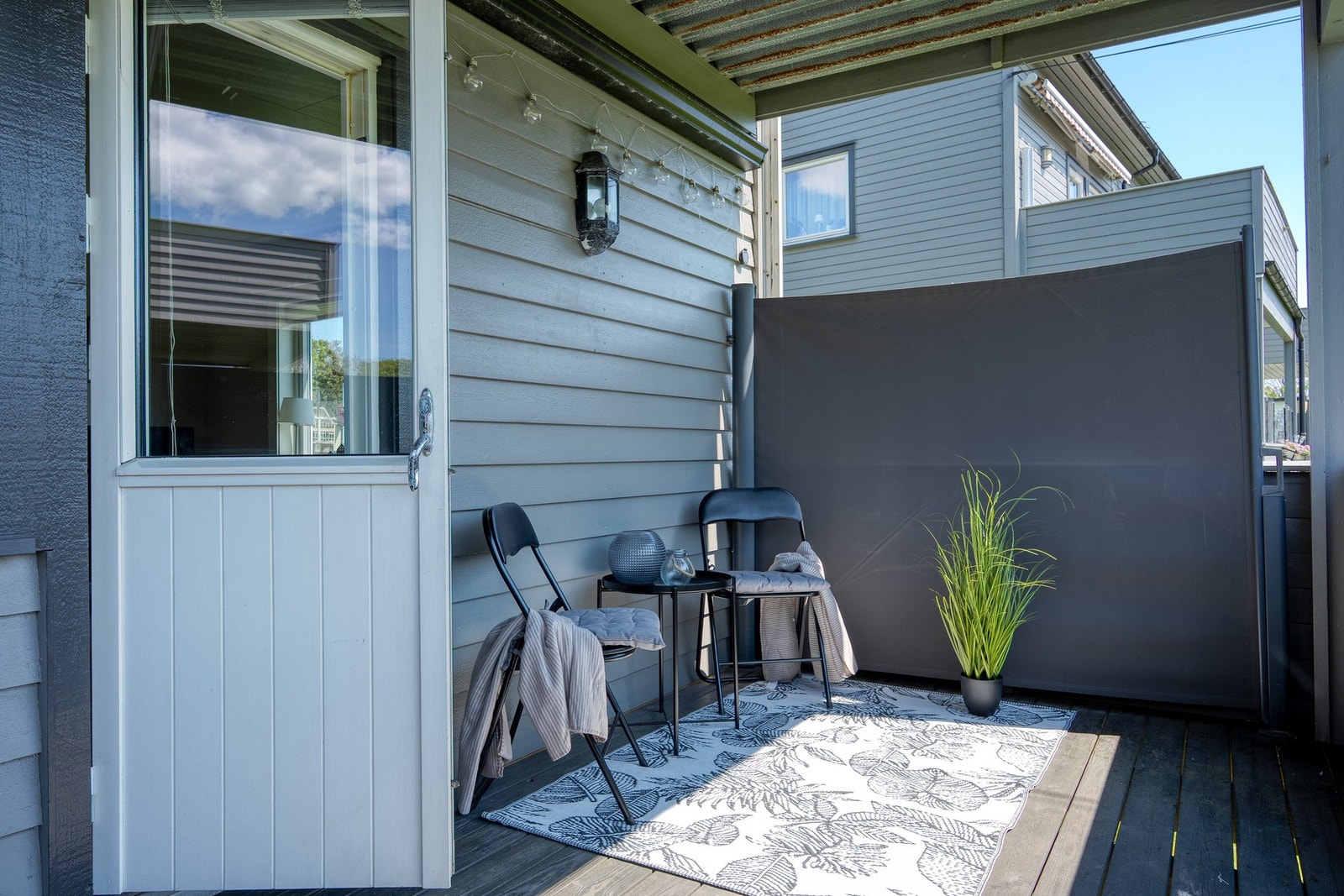 Overbygget veranda på 11 kvadratmeter. Vindskjerming er montert på veggene. Galleribilde