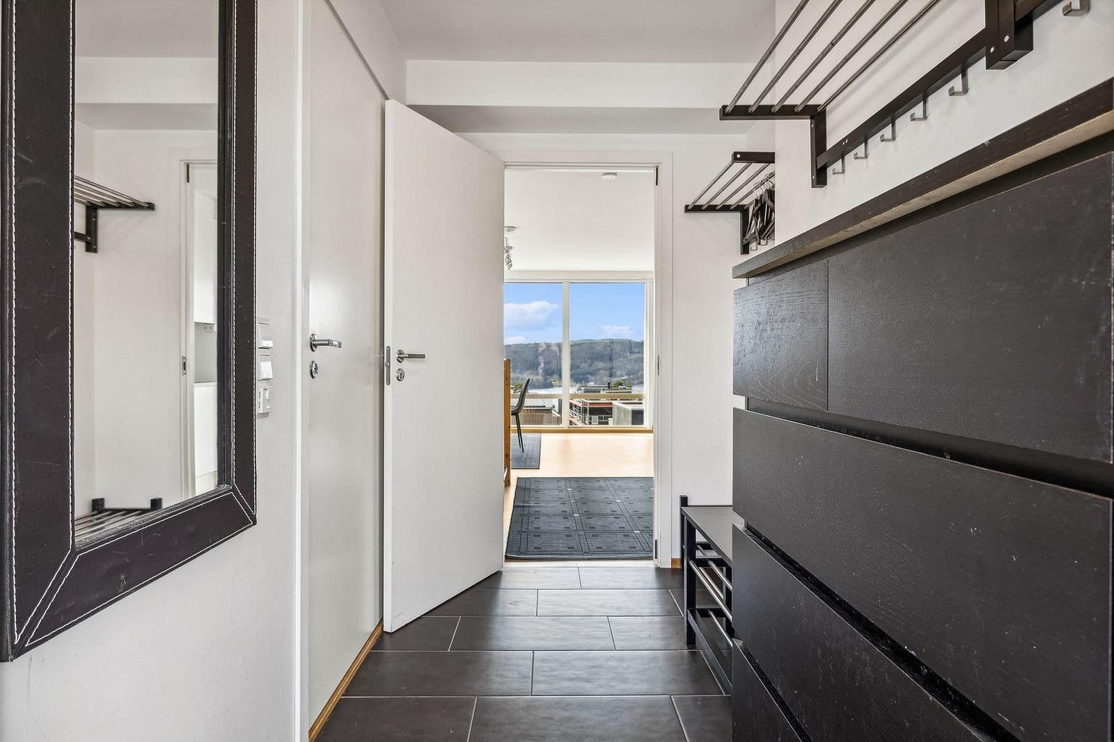 Lys entrè med fliser på gulv med varme i gulv. Her er det god plass til å henge fra seg yttertøy. Galleribilde