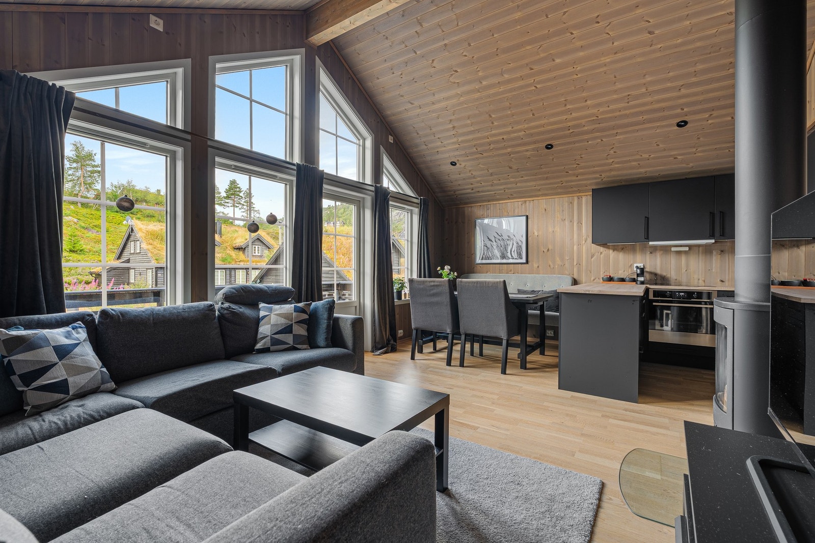 Romslig stue med store vinduer, åpen stue/kjøkkenløsning. Lys og luftig atmosfære. Galleribilde