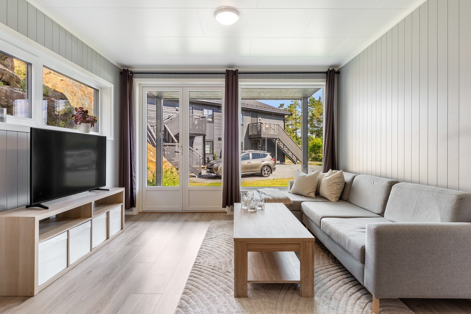 Lys og fin stue som får rikelig med naturlig lysinnslipp fra vindu Galleribilde