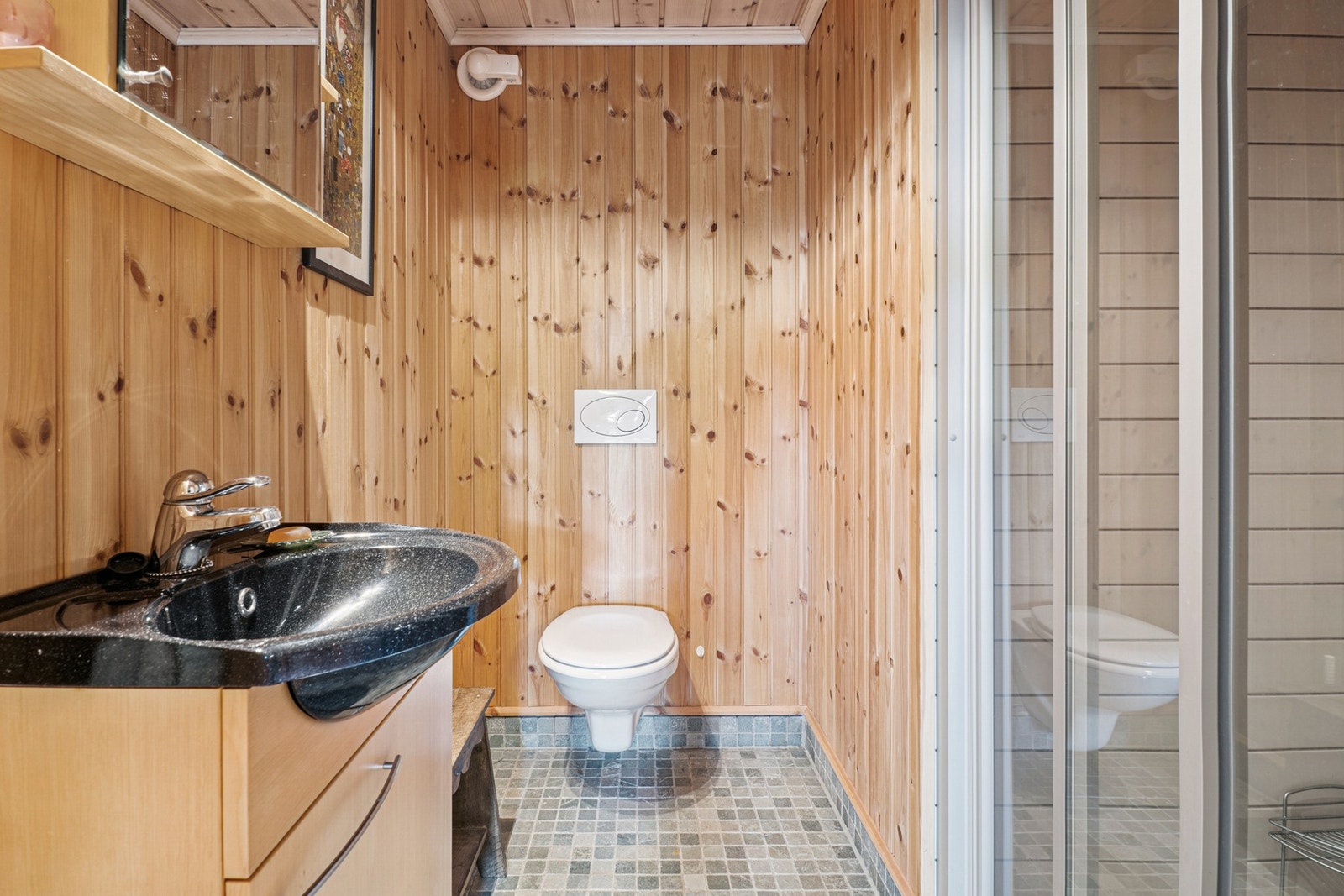 Badet er utstyrt med servantinnredning, dusjnisje og veggmontert WC. Galleribilde