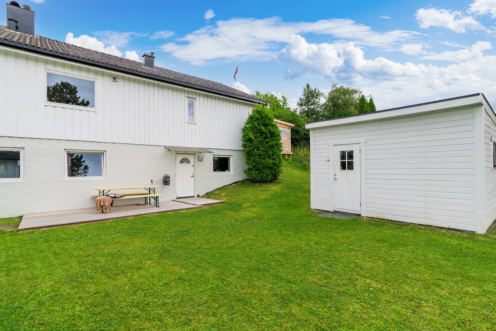 På nedsiden har man fin og flat hage pluss utebod. Galleribilde