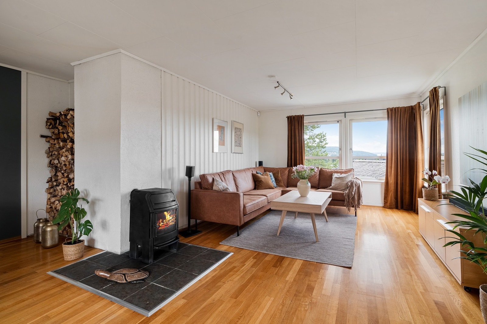 Ildstedet merker skillet mellom spiseseksjone og stuesonen, begge med romslig, møbleringsvennlig areal. Galleribilde