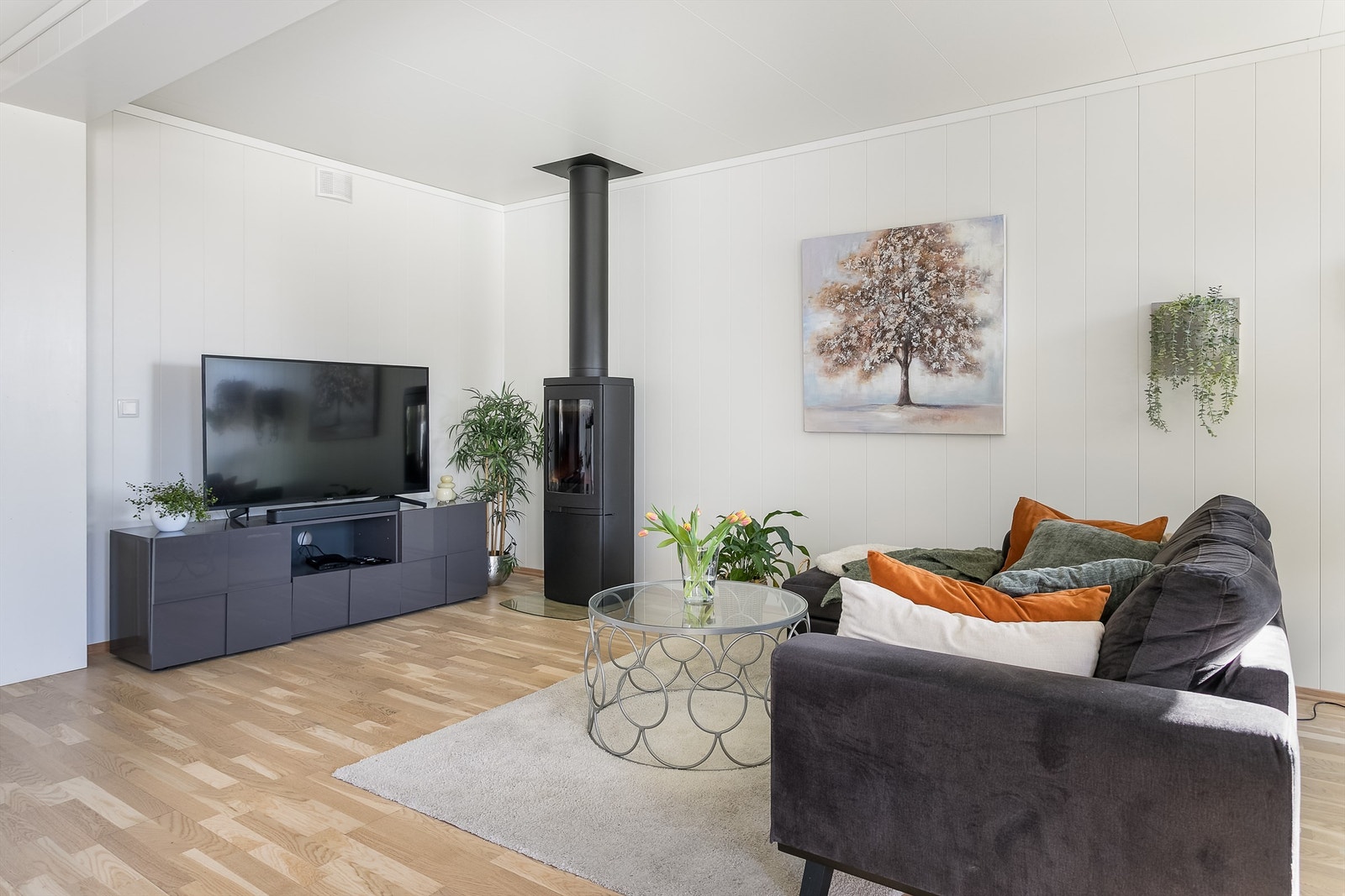 Stuens moderne vedovn kan gi varme til hele leiligheten. Oppvarming skjer for øvrig med hjelp av elektrisitet. Galleribilde