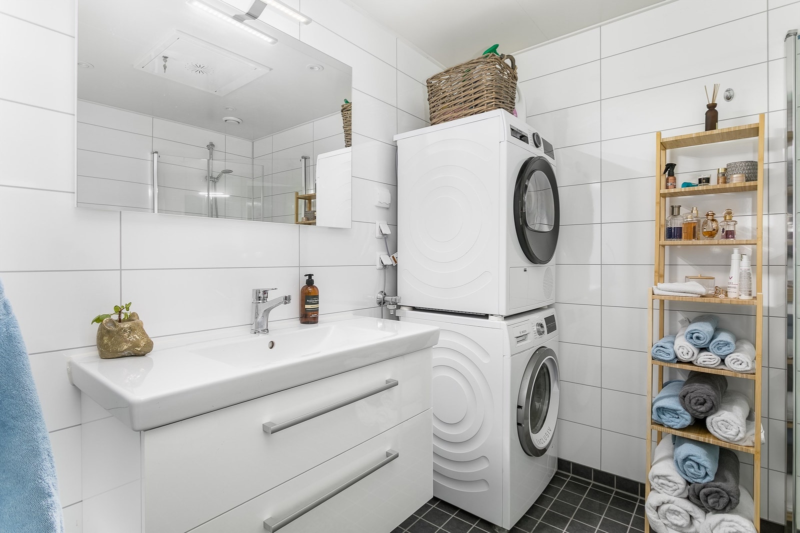 Badets gulv har fliser og varme, veggene er utført med flis-mønstrede våtromsplater. Galleribilde