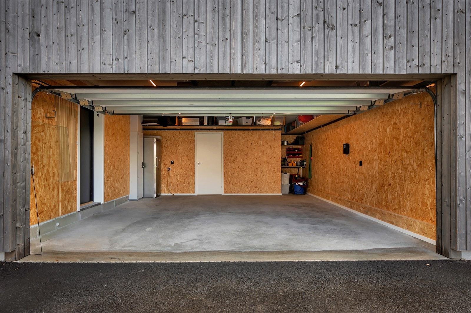Garasje med 32 Amp El-billader, bod og inngang til vaskerom. Her kan du gå tørrskodd inn Galleribilde