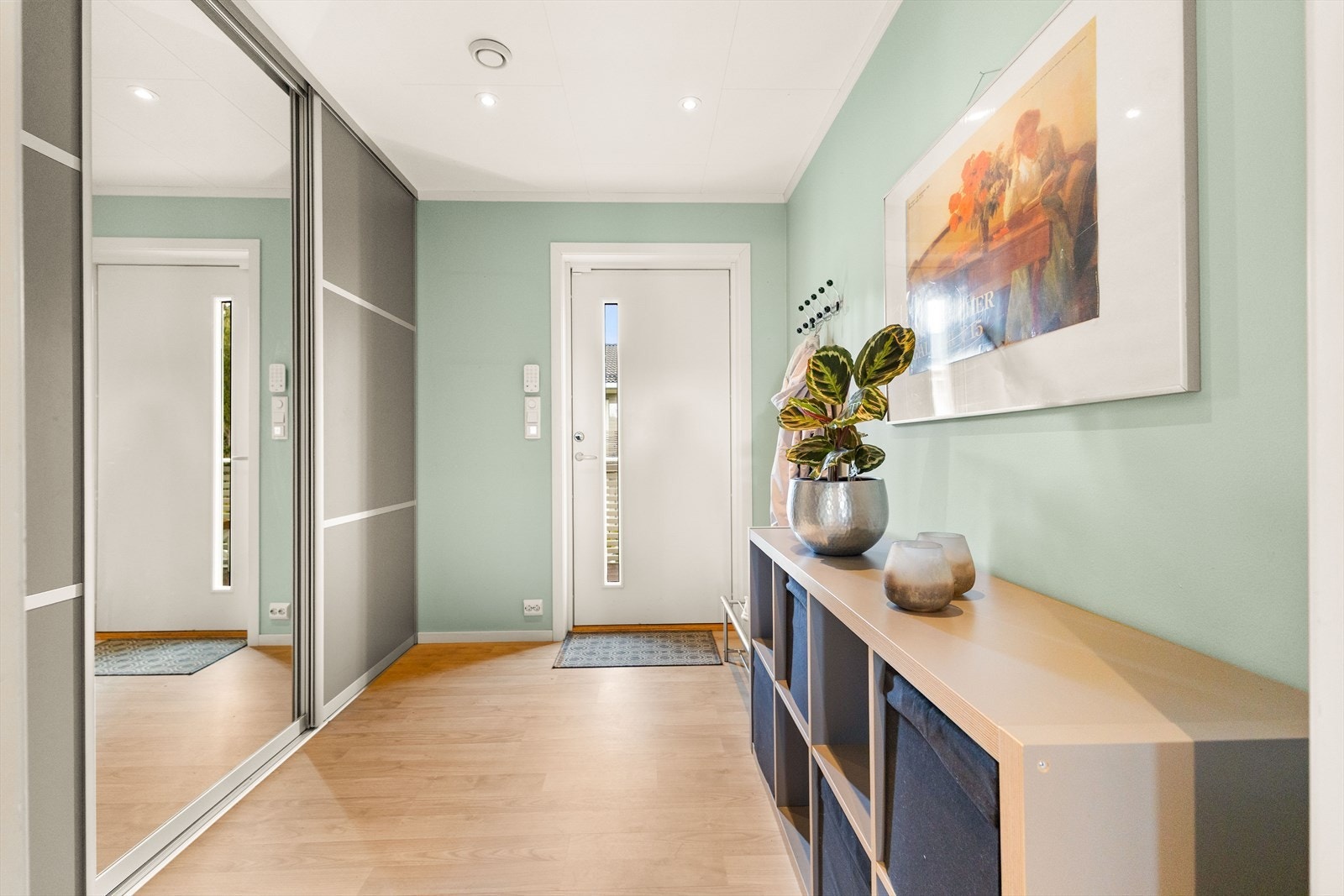 Leiligheten har en lys og romslig entré med en stor- og praktisk skyvedørsgarderobe og plass til annen oppbevaring. Galleribilde