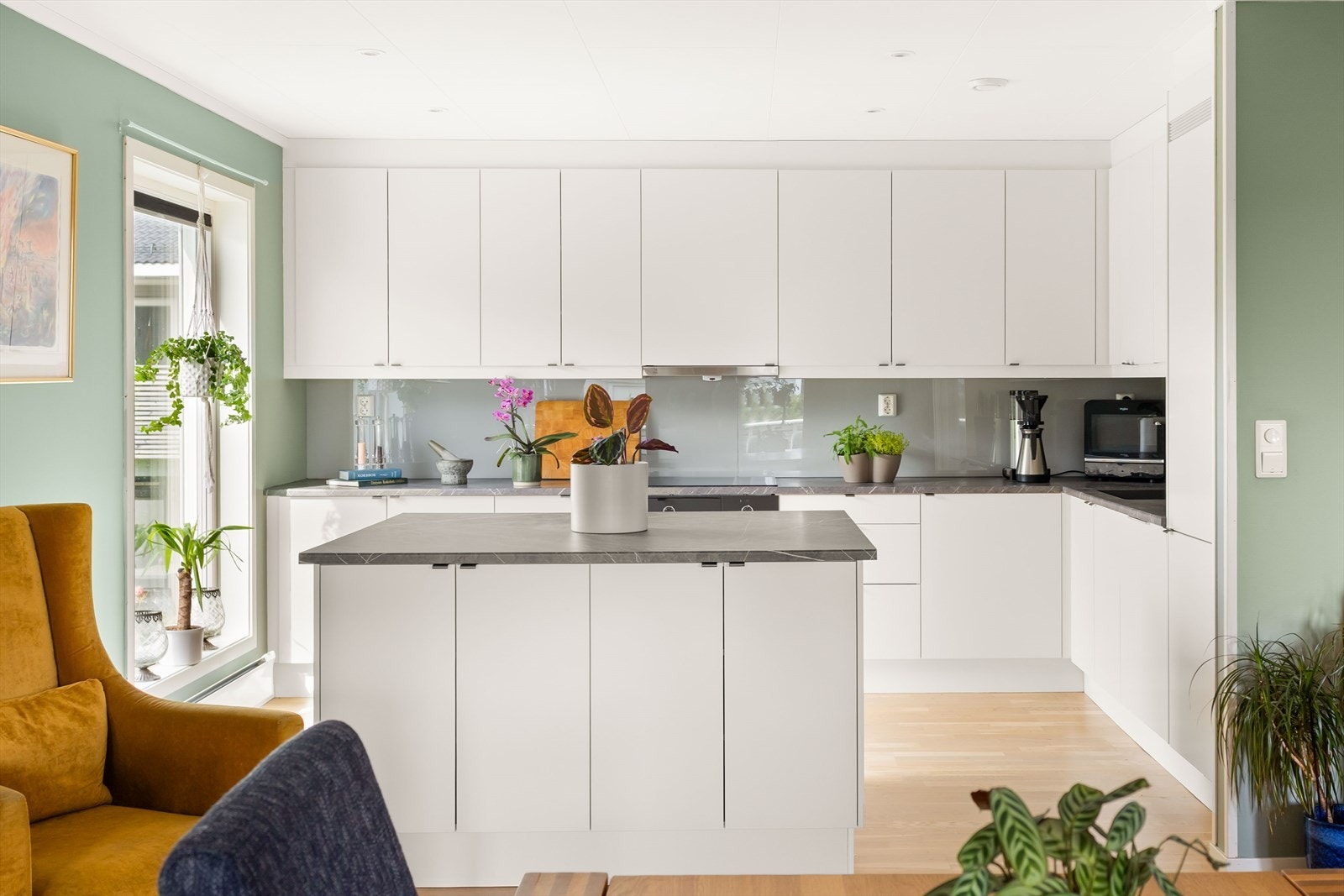 Kjøkkenet har en meget pen og tidløs kjøkkeninnredning fra kvalitetsleverandøren Sigdal. Innredningen har hvite slette fronter, laminert benkeplate med underlimt vask. Det er montert glass mellom benk og overskap. Galleribilde