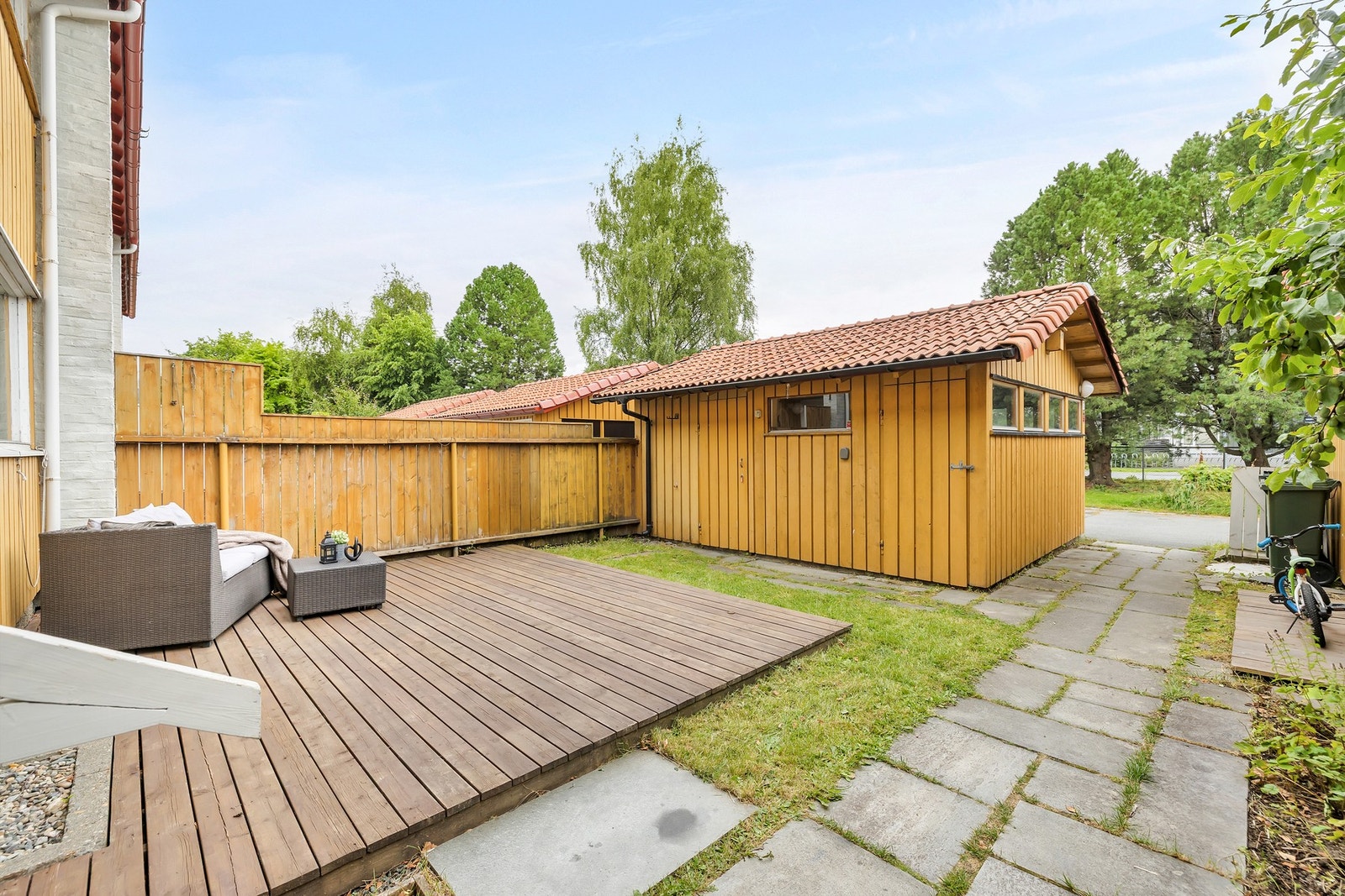 Pent opparbeidet uteområde med platting og hageflekk. Galleribilde