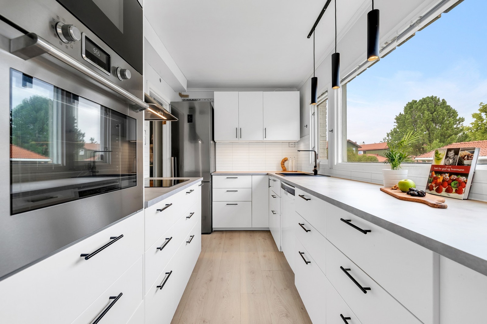 Lyst og moderne kjøkken fra 2023 med masse skap- og benkeplass. Galleribilde