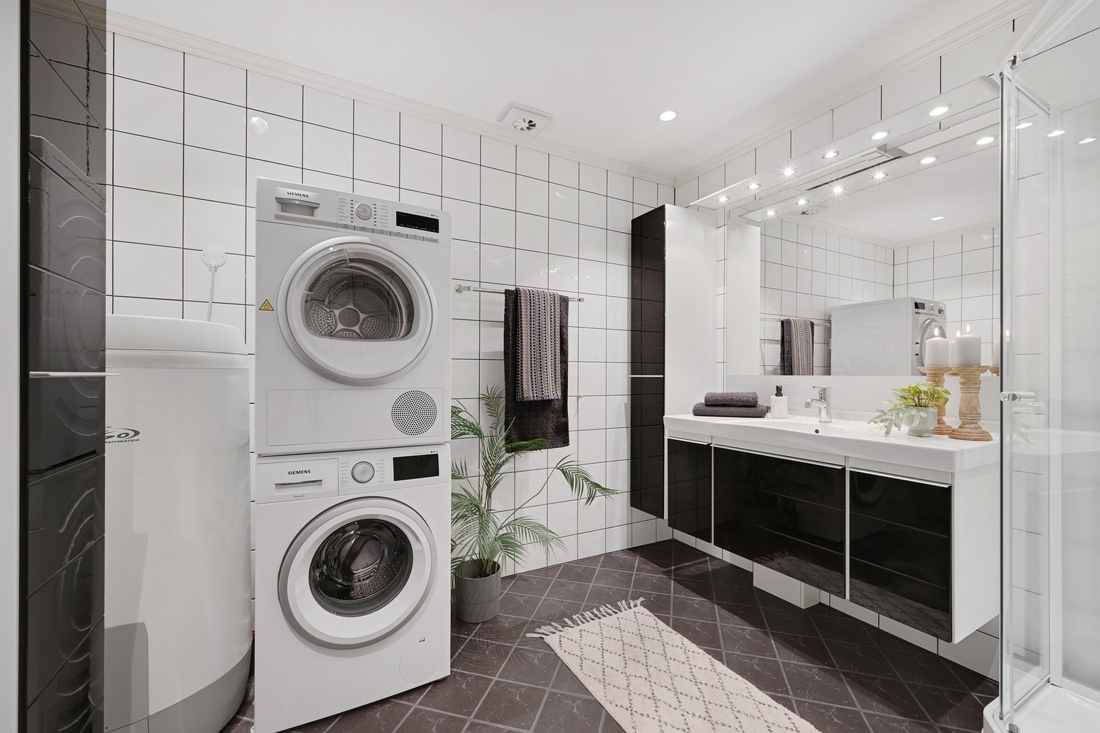 Badet har flis på gulv og vegger, downlights i taket og varmtvannsbereder plassert i hjørnet. Galleribilde