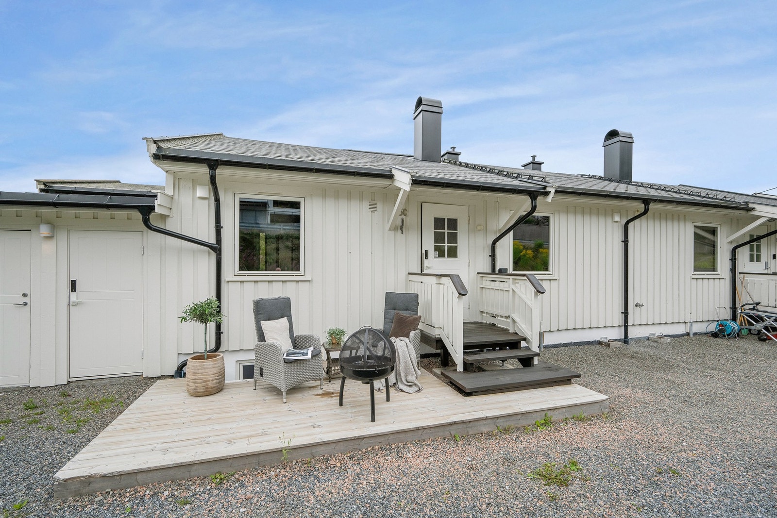 Tomten er pent opparbeidet med grus og leder ann til det hyggelige inngangspartiet. Her parkerer man rett utenfor inngangsdøren med tilknyttet elbil-lader fra Easee. Galleribilde