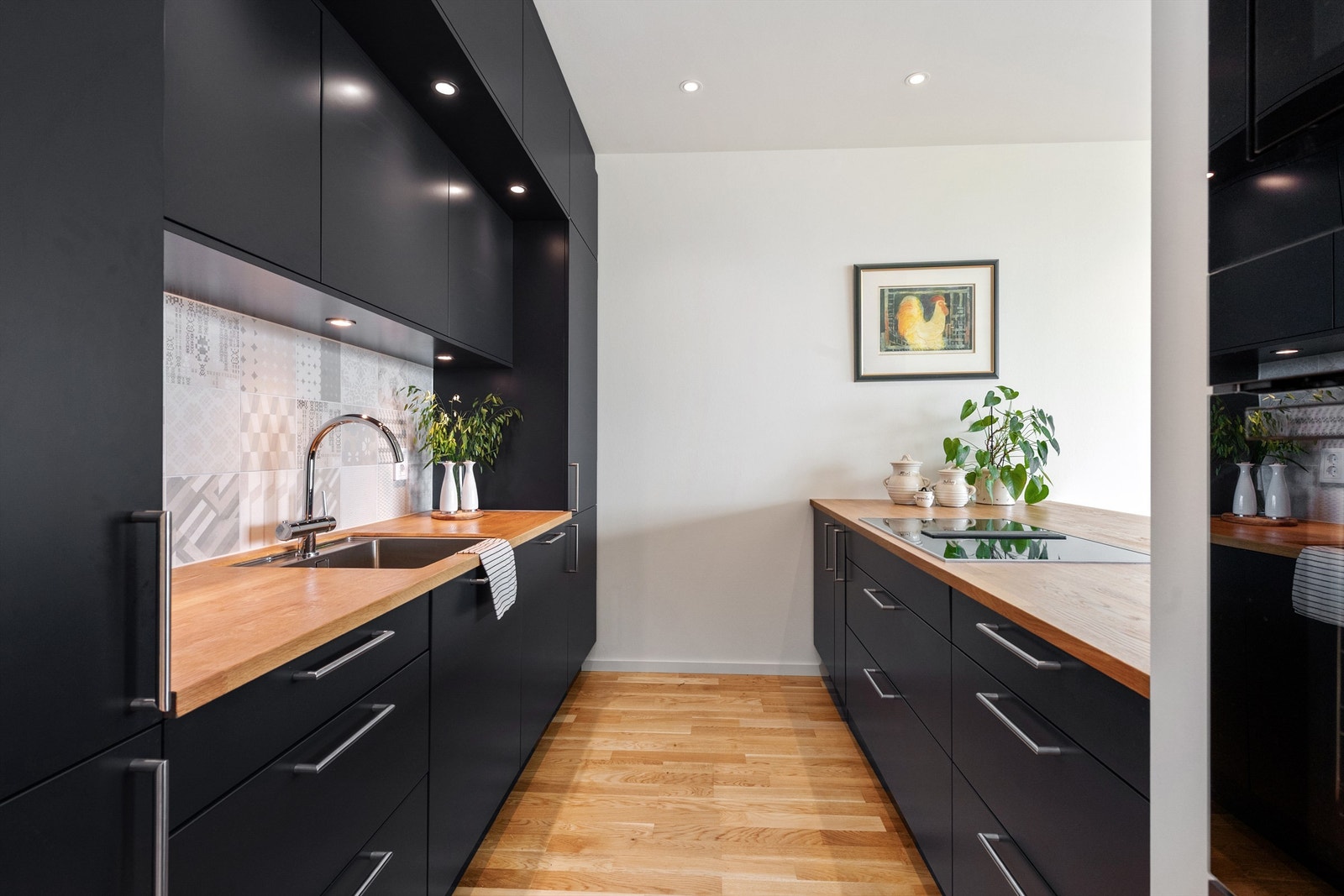 HTH kjøkkeninnredning med både mørke og hvite glatte fronter og benkeplate av heltre Galleribilde