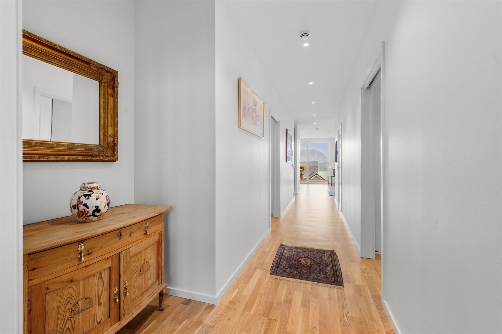 Fra gang/inngangsparti mot stue. Lyse overflater i gang med hvite glatte innerdører Galleribilde