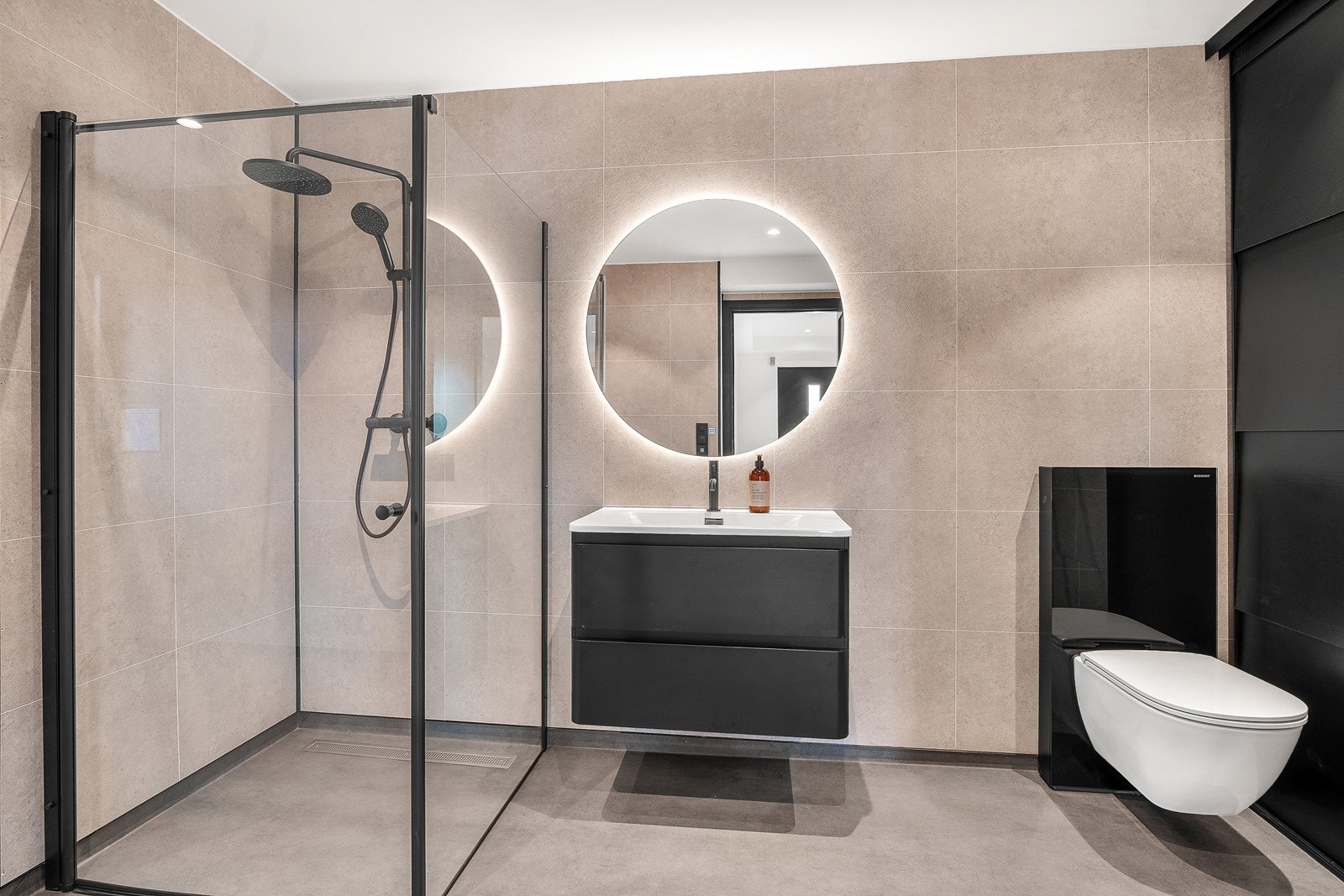 Badet har elegante fibotresbo våtromsplater på vegg, og medfølger vegghengt klosett, flott innredning med servant, speilfelt og lys. Galleribilde