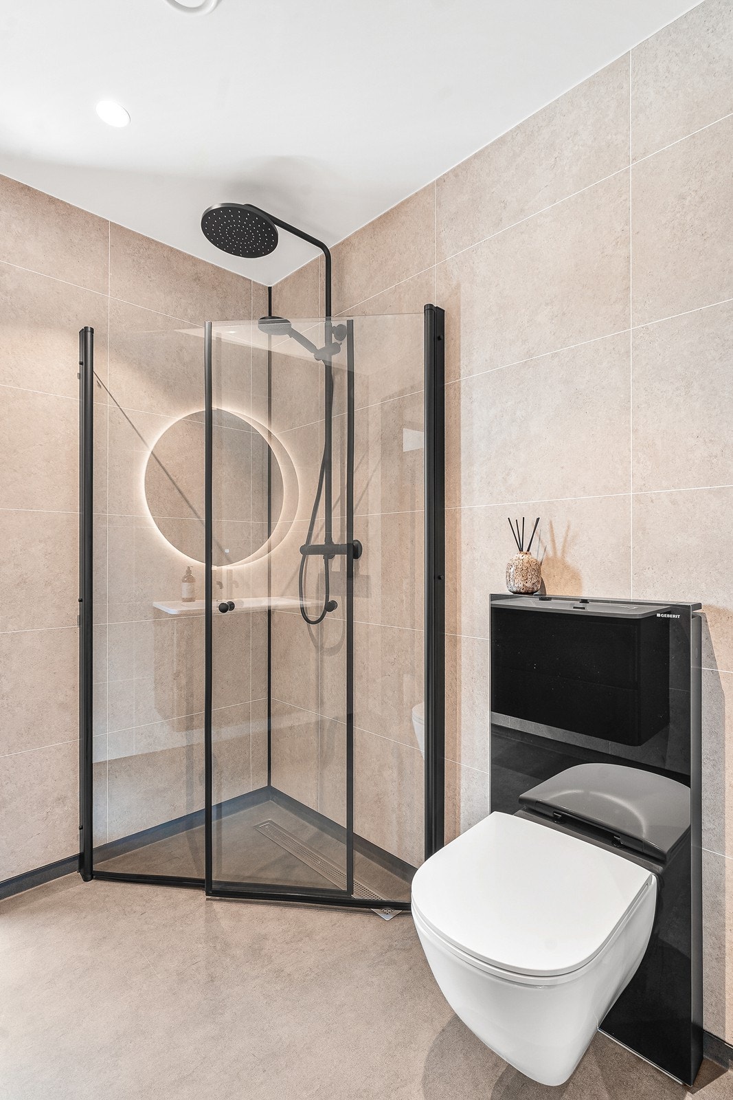 Badet er innredet med innfellbart dusjhjørne i glass, vegghengt klosett og påkostet med flott innredning med servant, speilfelt og lys. Galleribilde