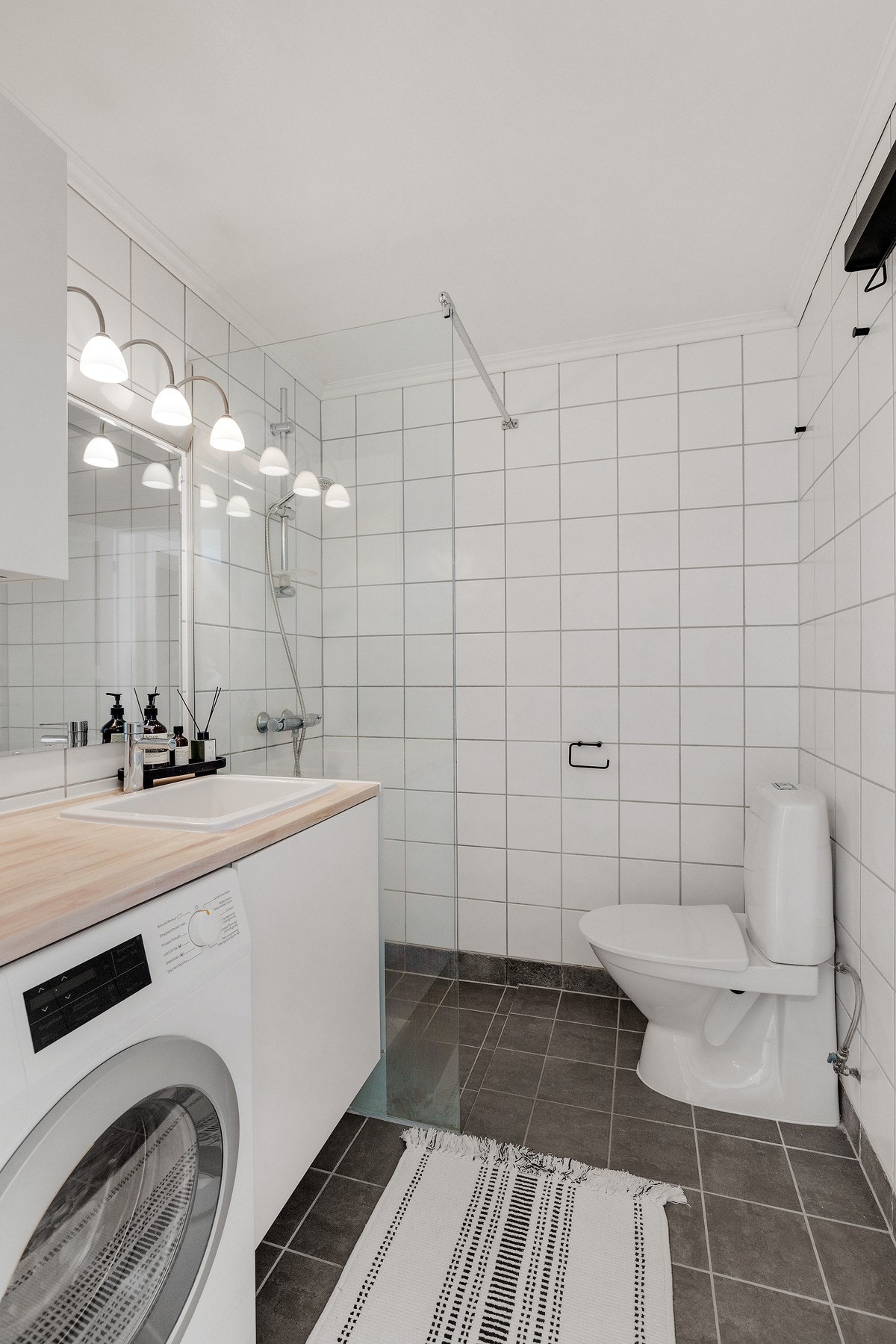 Innredningen er bestående av heltre benkeplate med nedfelt keramisk servant, underskap, overskap, speil med lys over, frittstående toalett og opplegg for vaskemaskin. Galleribilde