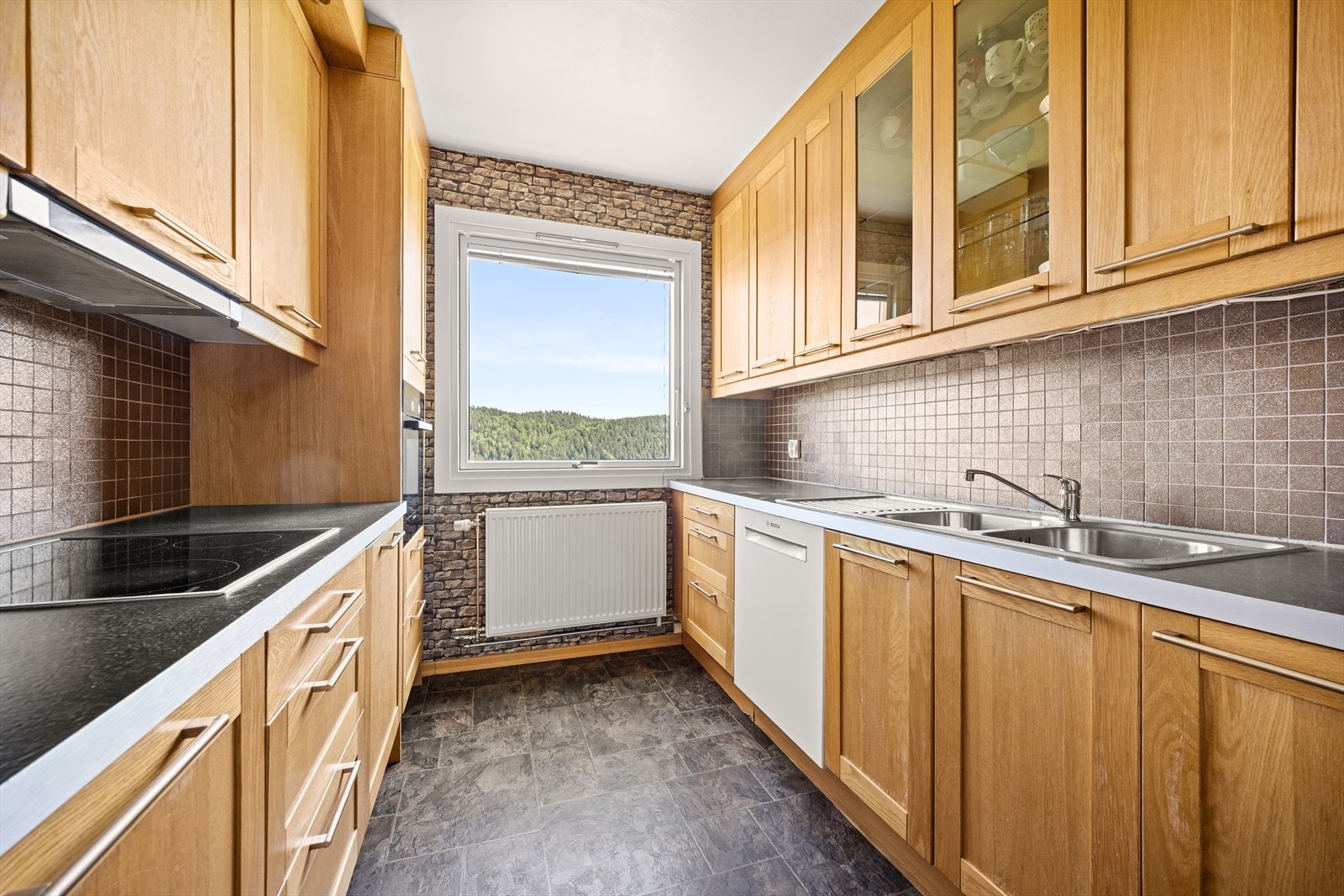 Kjøkken med innredning fra Epoq og har profilerte fronter, flislagt over kjøkkenbenk og benkeplate i laminat Galleribilde