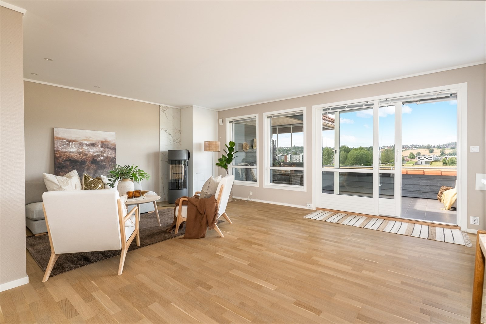 Innbydende og romslig stue med åpen kjøkkenløsning, store vindusflater og skyvedør til veranda. Galleribilde