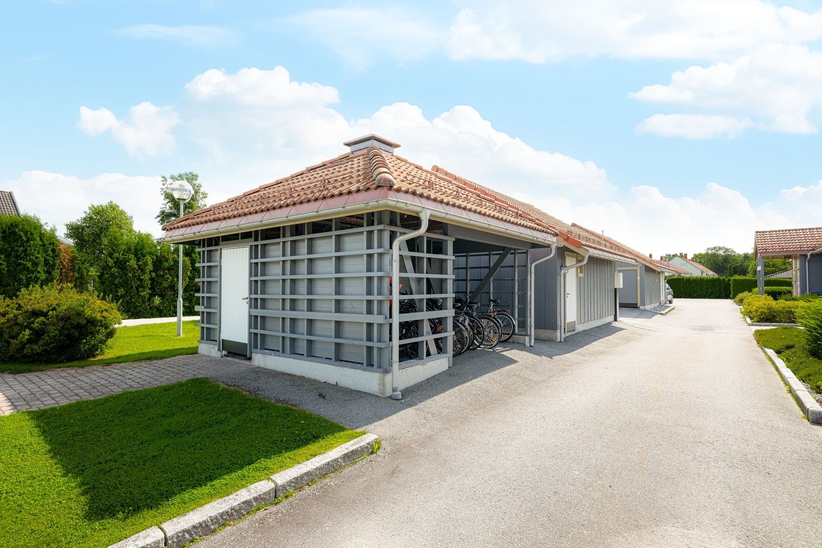 Asfalterte internveier og parkeringsplasser. Frittstående garasjer og felles garasjeanlegg med heis til bakkeplan. Galleribilde