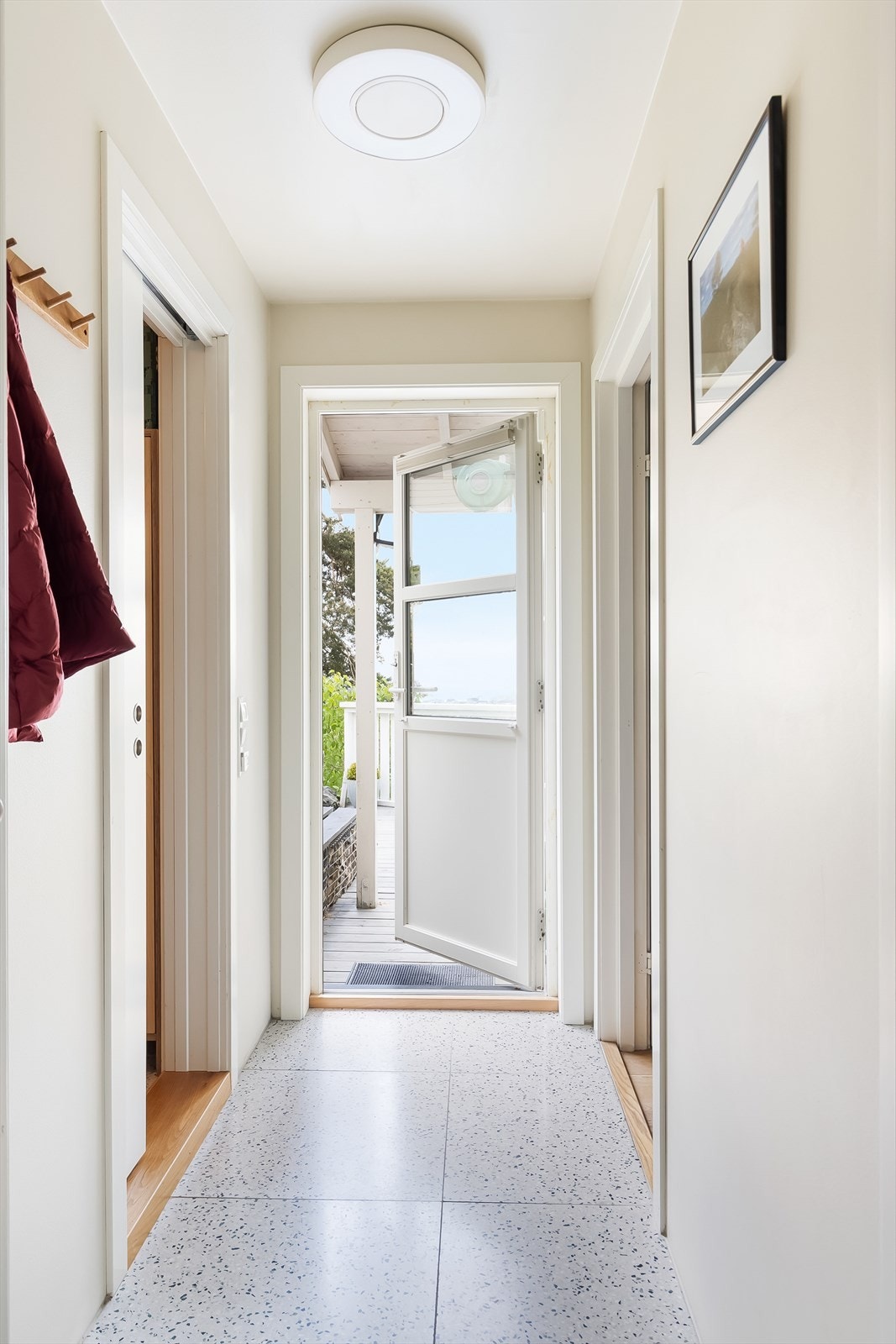 Flislagt vindfang som leder ut til terrassen Galleribilde