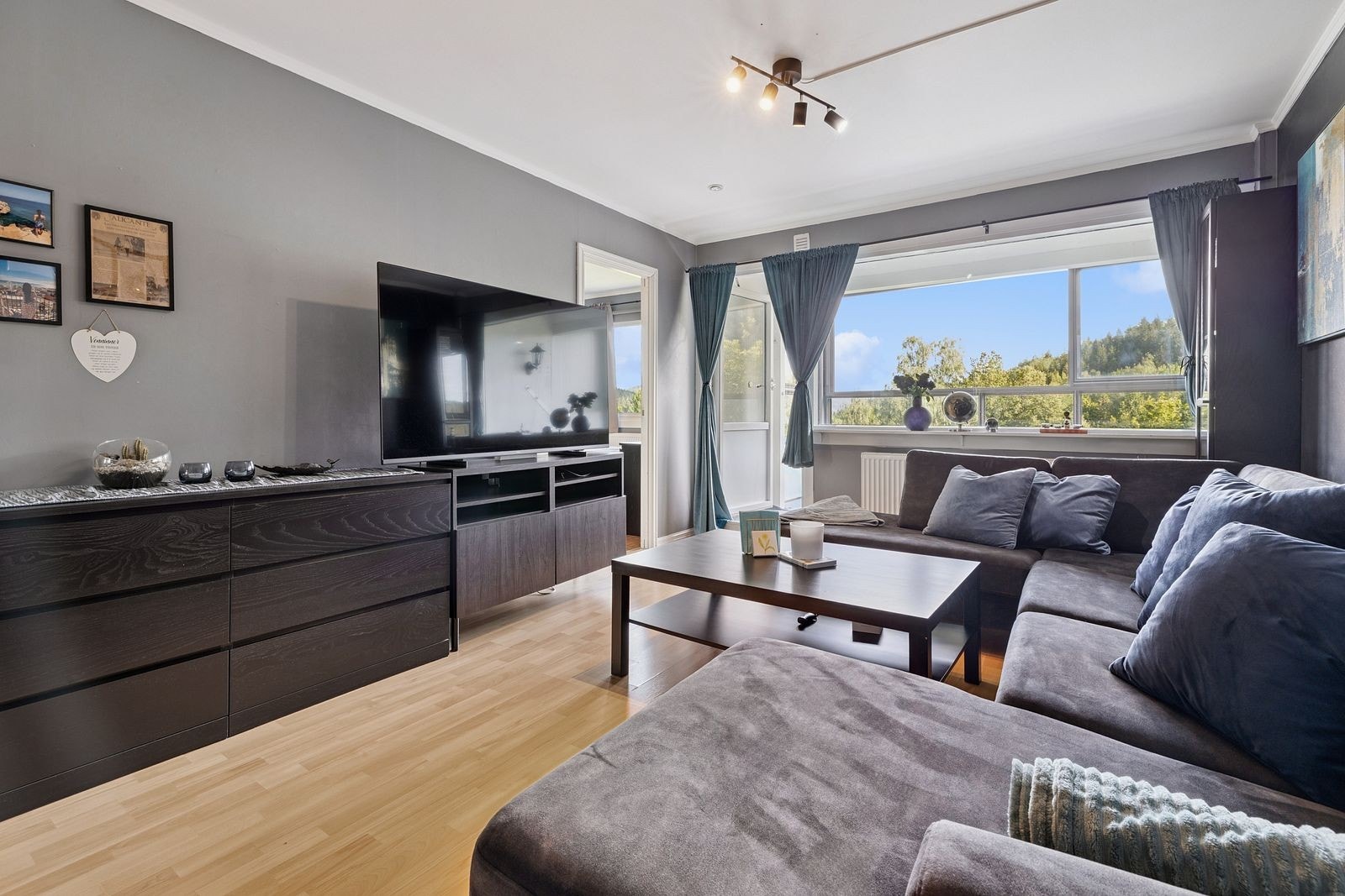 Harmonisk atmosfære med plass til sofagruppe, TV og personlige detaljer. Galleribilde