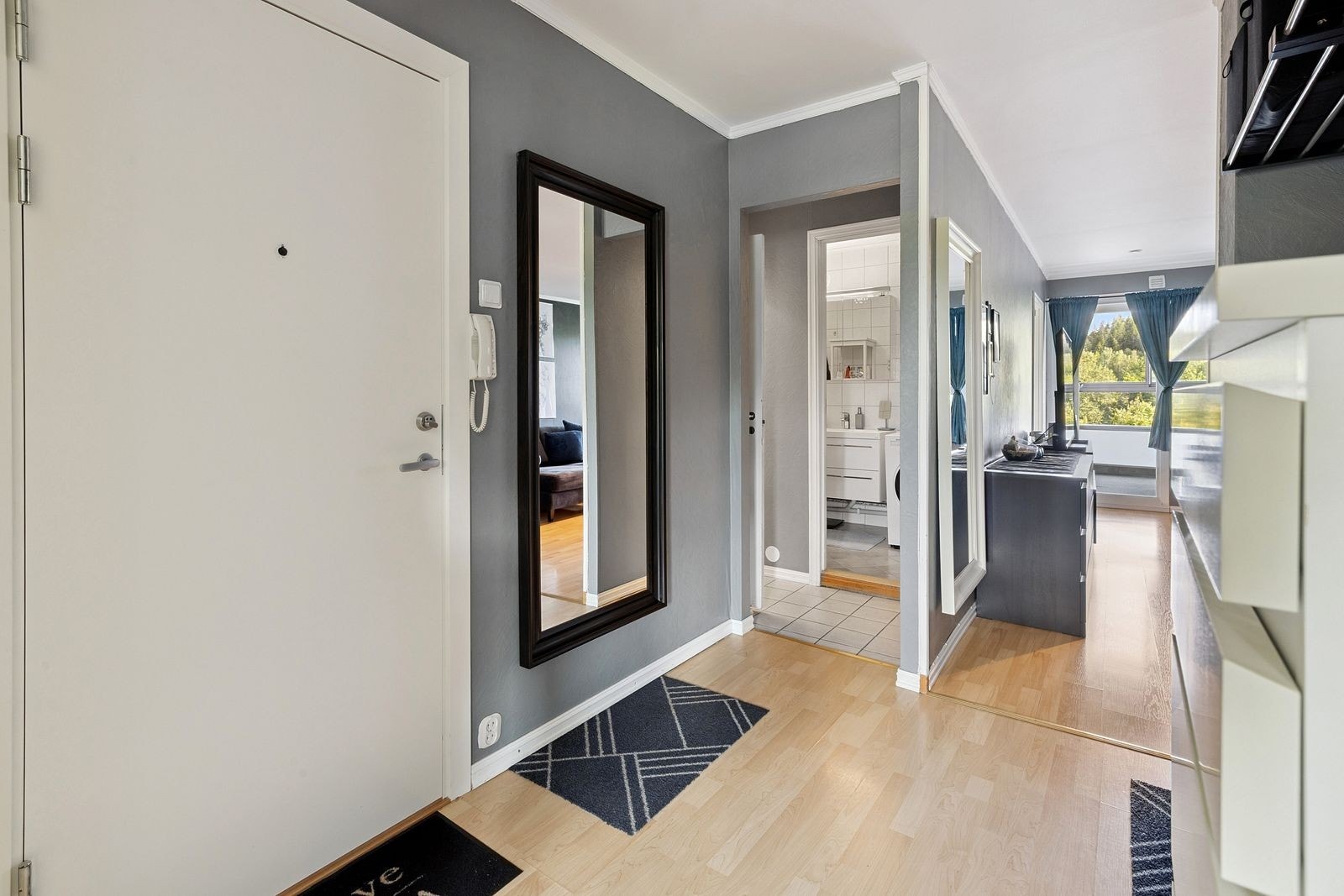 En romslig og smart inngang som gir deg et glimt av resten av boligen. Galleribilde