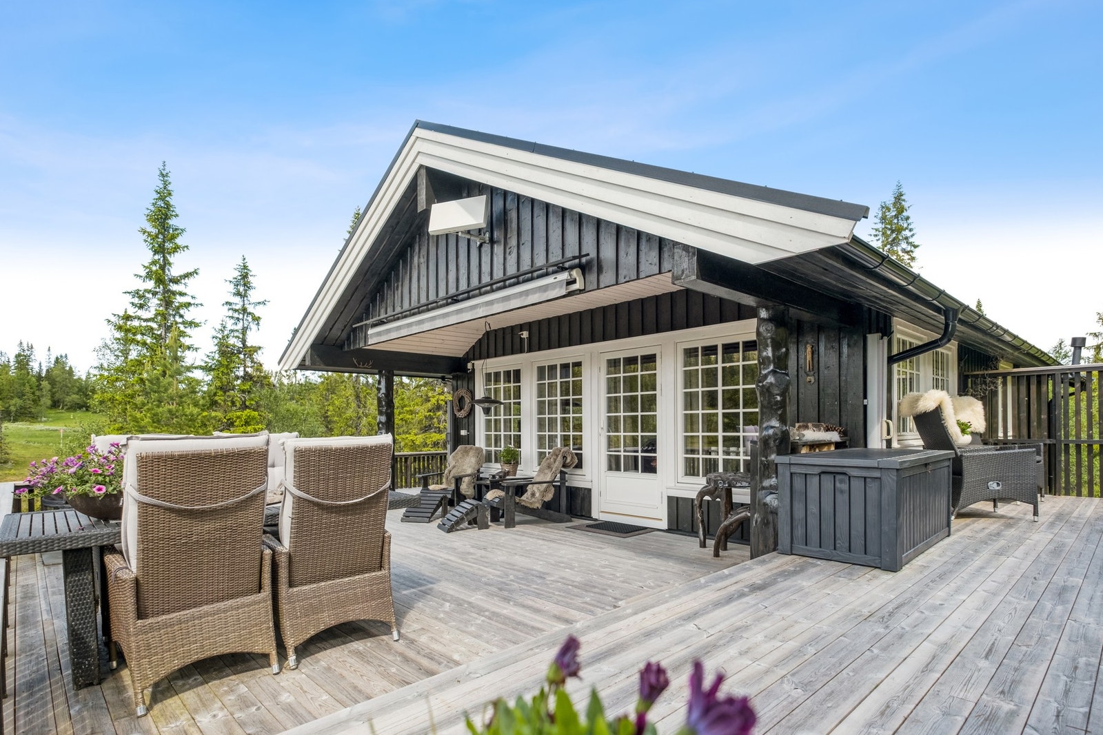 Fra stuen har man utgang til uteplassene, hvor deler er takoverbygd. Galleribilde