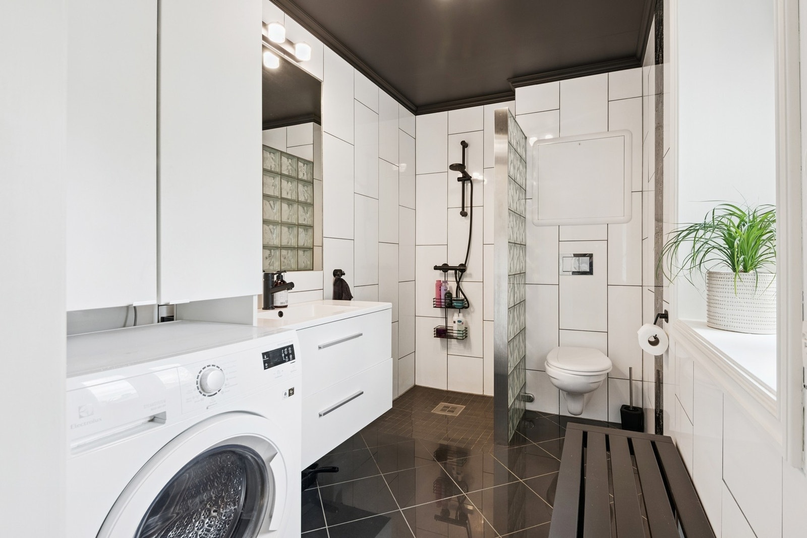 Badet har god plass til oppbevaring i innredning, samt avsatt plass til vaskemaskin. Galleribilde